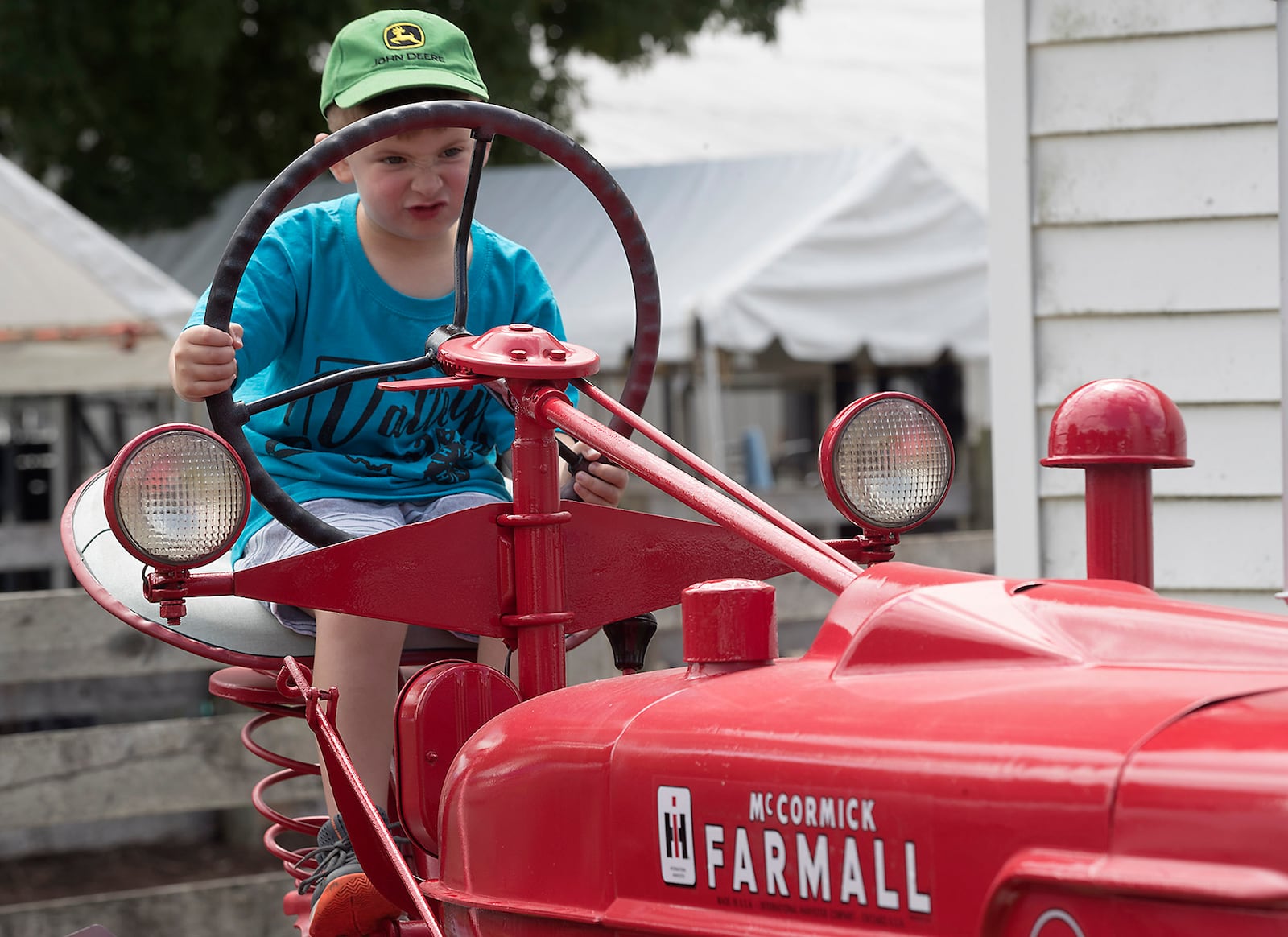 Ethan Napier, 4, pretends to drive a tractor Tuesday at the Champaign County Fair. BILL LACKEY/STAFF