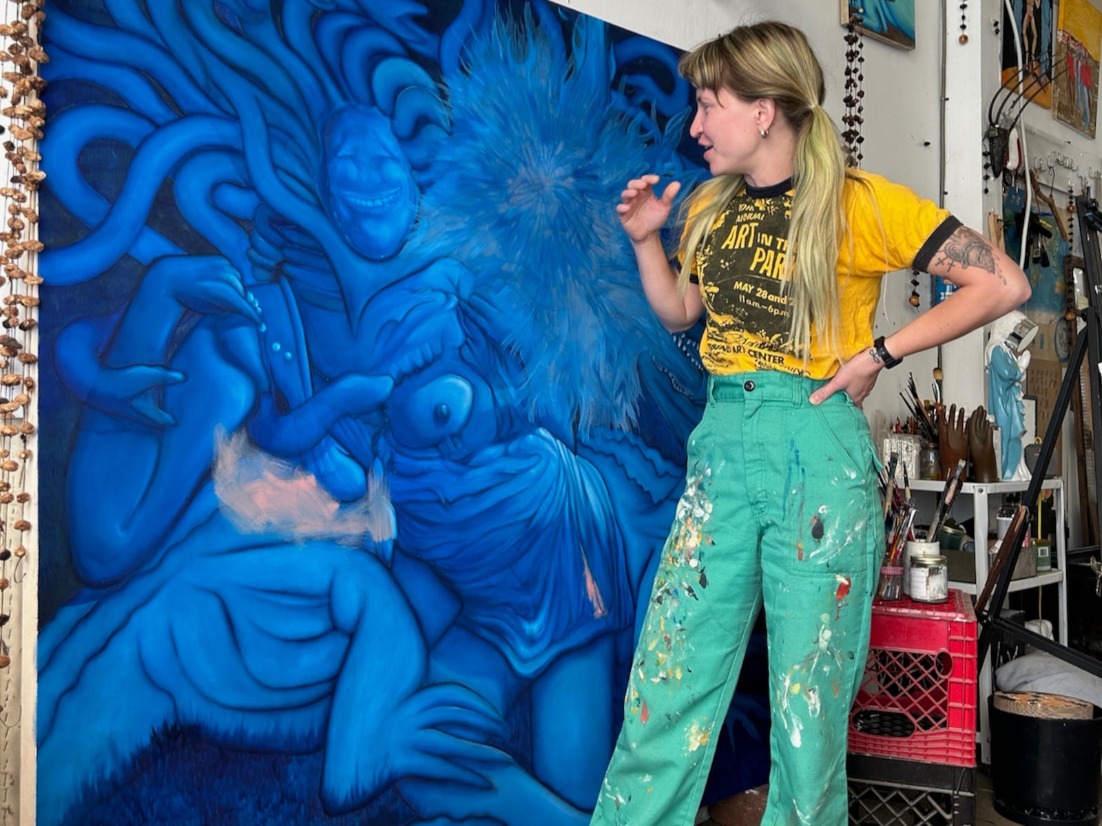 Artist Ashley Speelman in her studio with a work in progress. A childhood memory of persisting through a freezing open water race led her to paint blue people. “I kept wanting to stop. People were getting taken out in boats because they were too cold. That was such a pivotal moment in my life. I will never forget that imagery.”