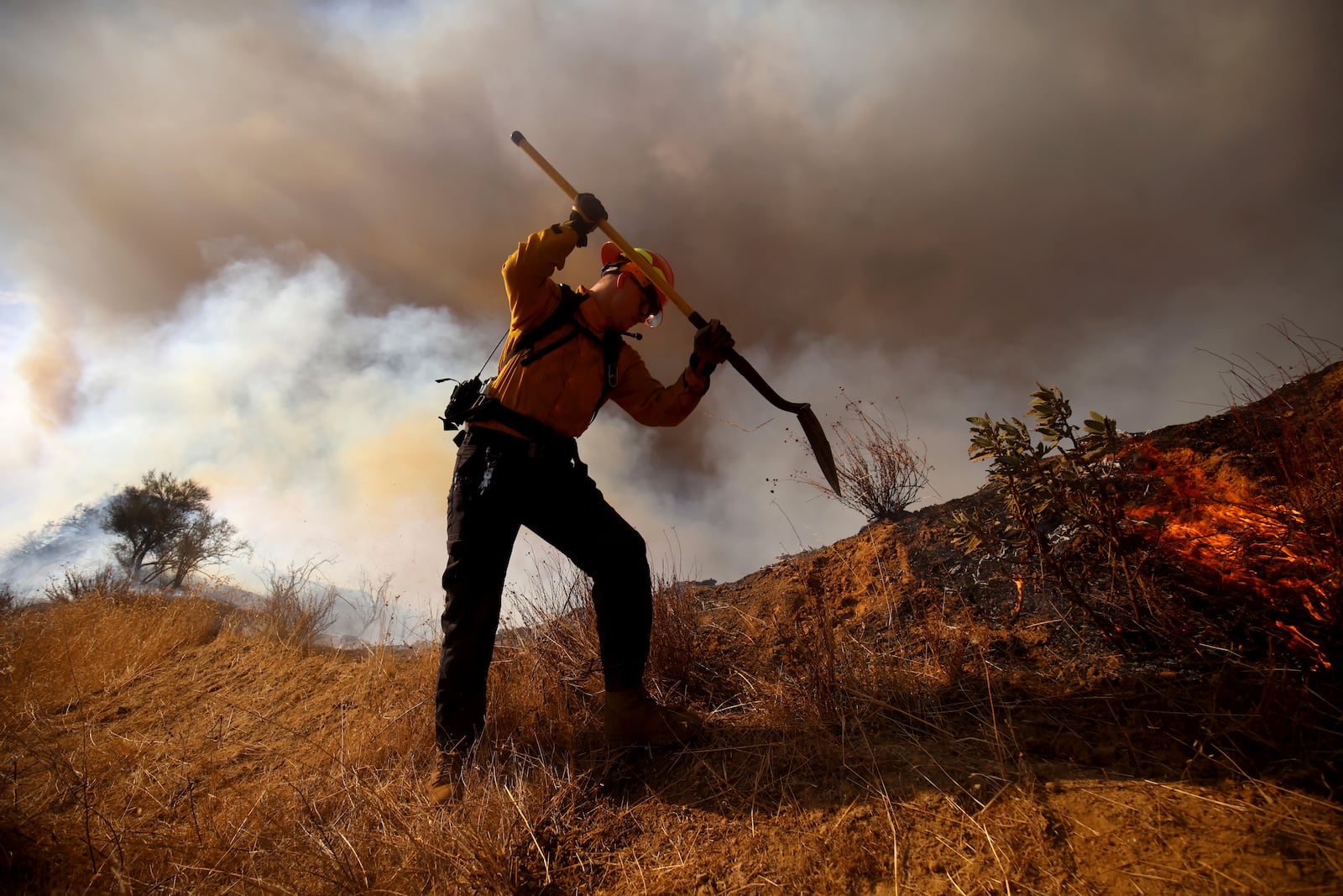 A firefighter works to control the spread of the Hughes Fire in Castaic, Calf., Wednesday, Jan. 22, 2025. (AP Photo/Ethan Swope)