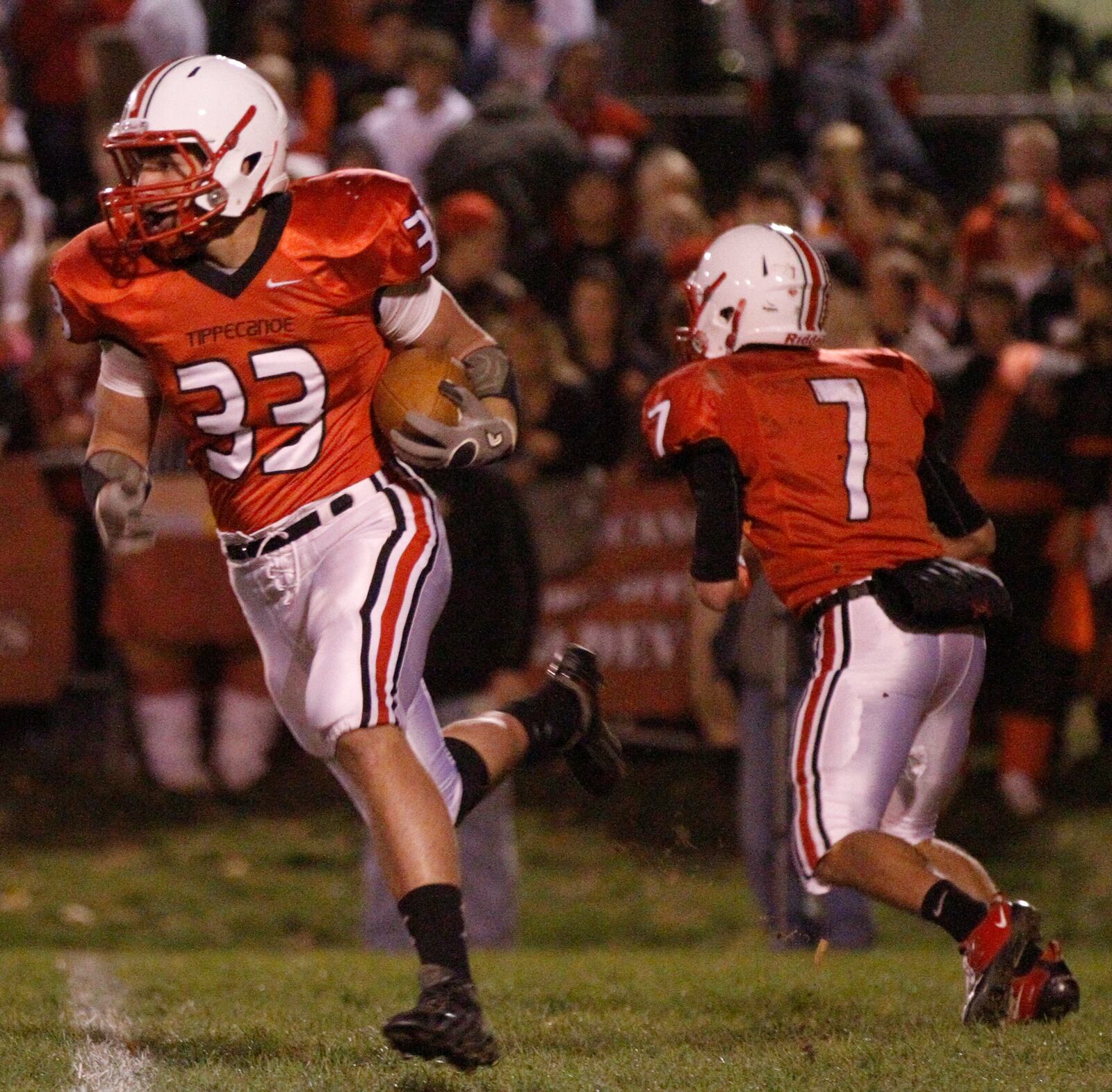 Jacob Hall (33) of Tippecanoe takes the hand-off from quarterback Ben Hughes (7) during Friday's football game against Tecumseh in Tipp City on October 12, 2012. Barbara J. Perenic/Springfield News-Sun