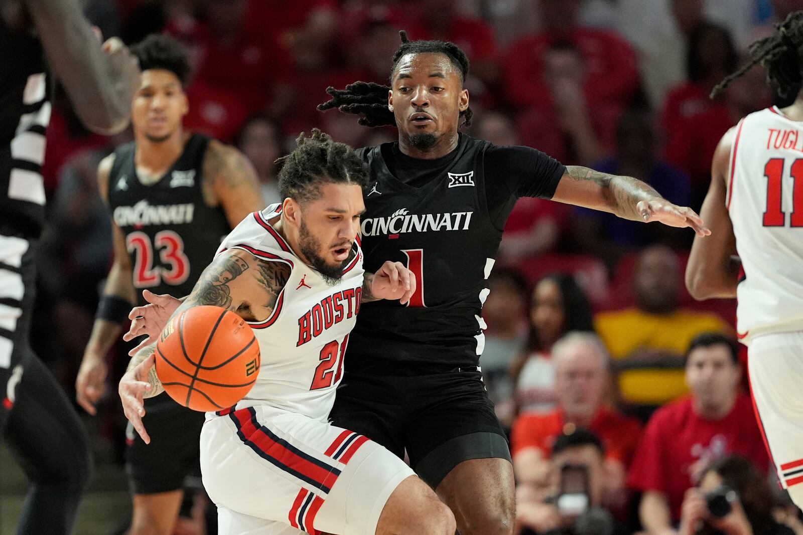 Cincinnati's Day Day Thomas (1) defends against Houston's Emanuel Sharp during the first half of an NCAA college basketball game Saturday, March 1, 2025, in Houston. (AP Photo/David J. Phillip)