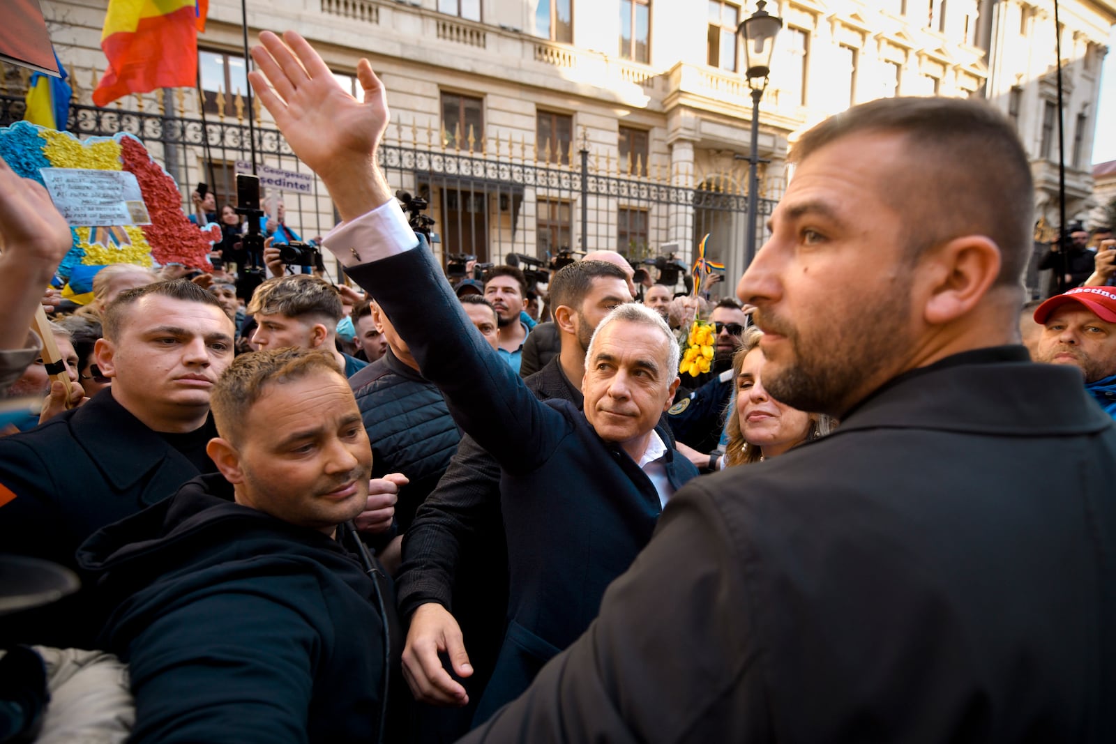 Calin Georgescu, the winner of the first round of presidential elections, later annulled by the Constitutional Court, waves to supporters after registering his new bid for the country's presidency outside Romania's Electoral Authority, in Bucharest, Romania, Friday, March 7, 2025. (AP Photo/Alexandru Dobre)