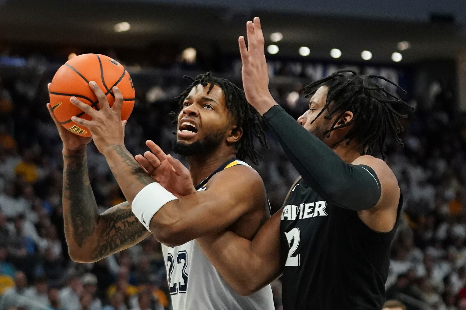 Marquette's David Joplin (23) drives to the basket against Xavier's Jerome Hunter (2) during the first half of an NCAA college basketball game Saturday, Jan. 18, 2025, in Milwaukee. (AP Photo/Aaron Gash)