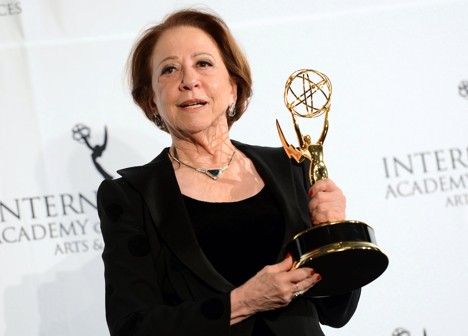 FILE - Brazilian actress Fernanda Montenegro poses with her "Best Performance by an Actress" award for her role in "Sweet Mother" at the International Emmy Awards Gala in New York, Nov. 25, 2013. (Photo by Evan Agostini/Invision/AP, File)