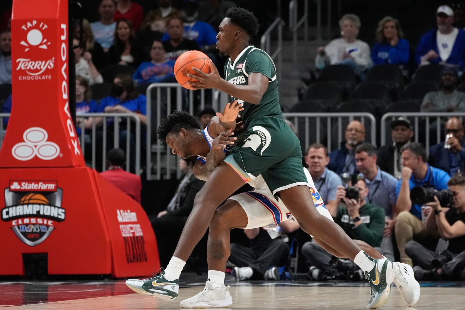 Michigan State forward Xavier Booker (34) collides with Kansas forward KJ Adams Jr. (24) during the first half of an NCAA college basketball game, Tuesday, Nov. 12, 2024, in Atlanta. (AP Photo/John Bazemore )