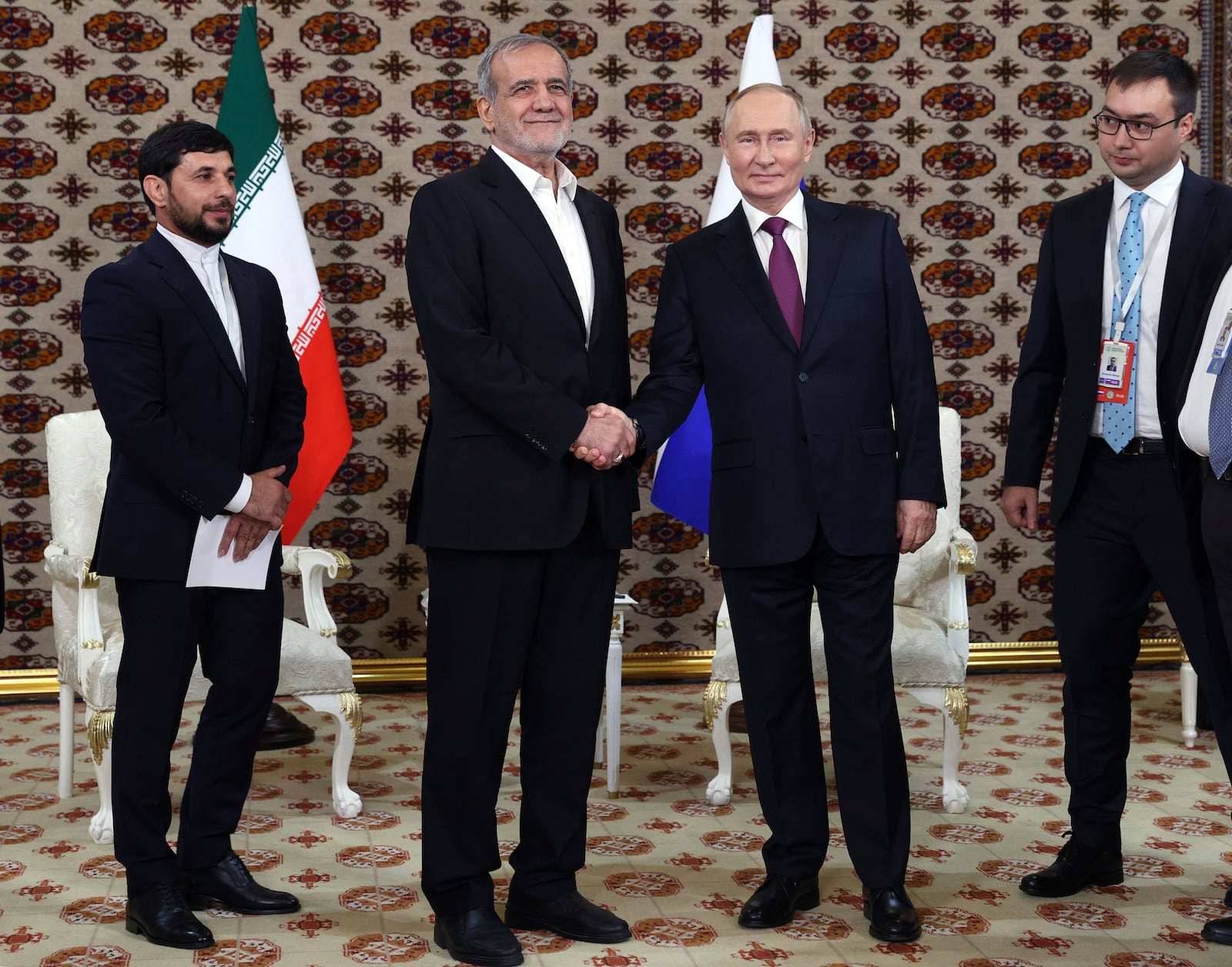 Russian President Vladimir Putin, center right, and Iranian President Masoud Pezeshkian, center left, shake hands during their meeting on the sidelines of the International Forum "The Interconnection of Times and Civilizations – the basis of peace and development" dedicated to the 300th anniversary of the birth of the outstanding Turkmen poet and thinker Magtymguly Fragi in Ashgabat, Turkmenistan, Friday, Oct. 11, 2024. (Sputnik, Kremlin Pool Photo via AP)