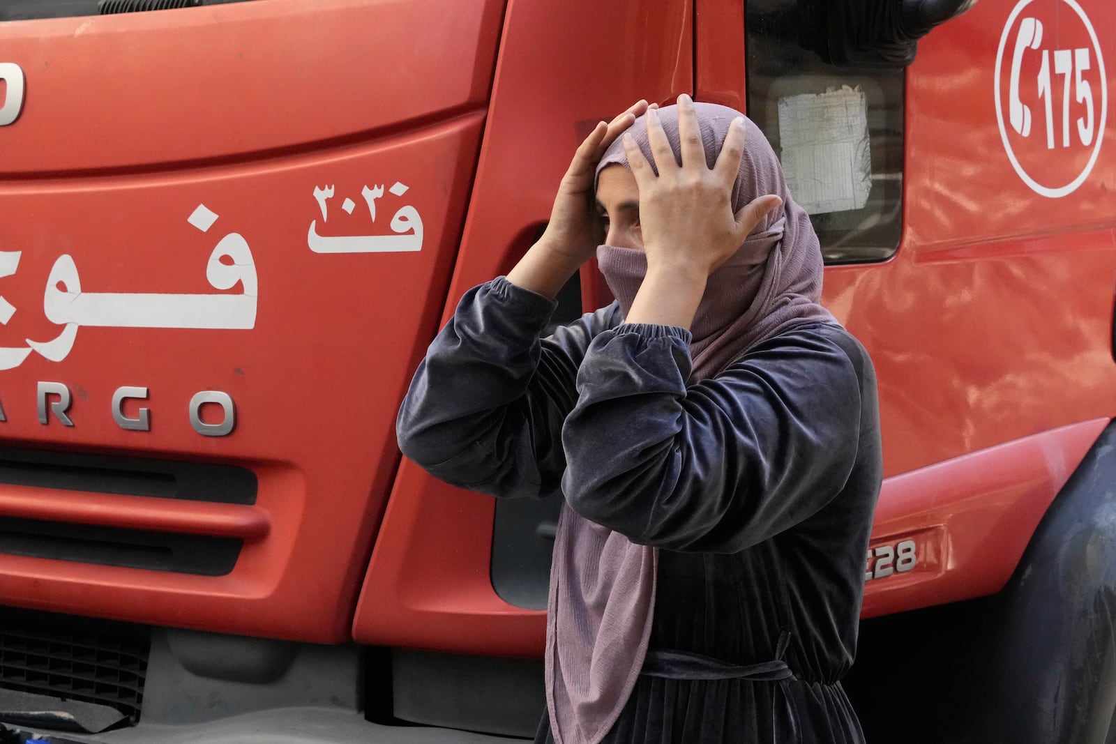 A Syrian woman mourns as rescue workers carry the body of a victim at the site of an Israeli airstrike that hit central Beirut, Lebanon, Saturday, Nov. 23, 2024. (AP Photo/Hassan Ammar)