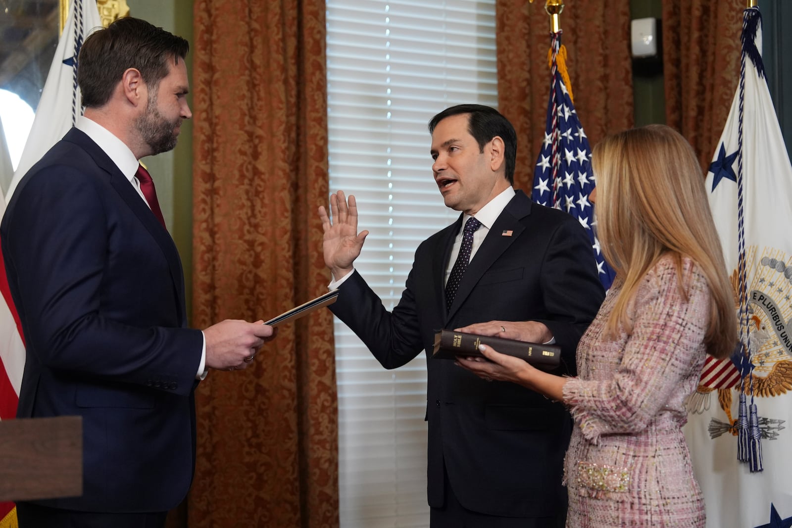 Secretary of State Marco Rubio is sworn by Vice President JD Vance in the Vice Presidential Ceremonial Office in the Eisenhower Executive Office Building on the White House campus, Tuesday, Jan. 21, 2025, in Washington, as his wife, Jeanette Rubio, looks on. (AP Photo/Evan Vucci)