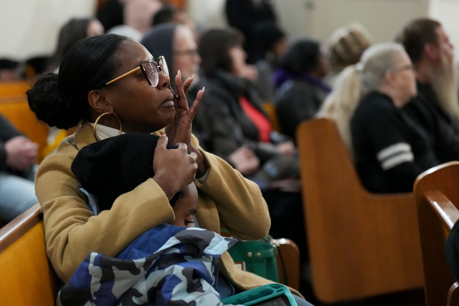 Alexus McGill wipes tears as she holds her son Devon Blackledge, 7, during a vigil for students that were killed and injured in a school shooting, Wednesday, Jan. 22, 2025, in Nashville, Tenn. (AP Photo/George Walker IV)