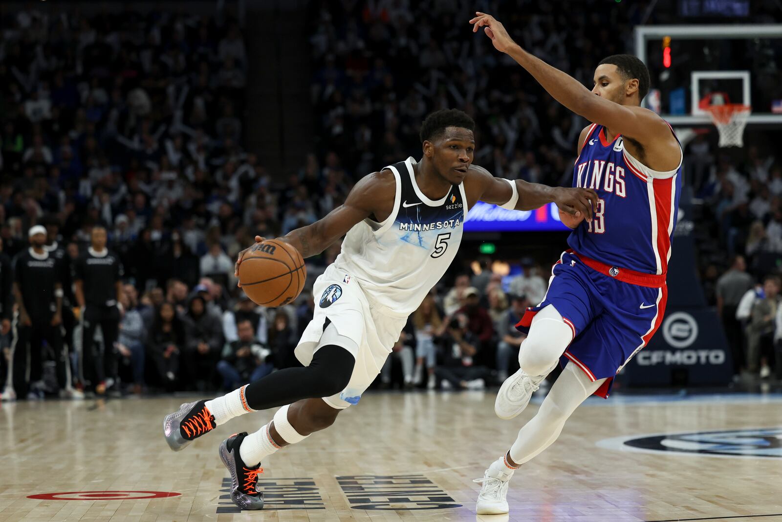 Minnesota Timberwolves guard Anthony Edwards (5) dribbles around Sacramento Kings forward Keegan Murray (13) during the second half of an NBA basketball game, Wednesday, Nov. 27, 2024, in Minneapolis. (AP Photo/Ellen Schmidt)