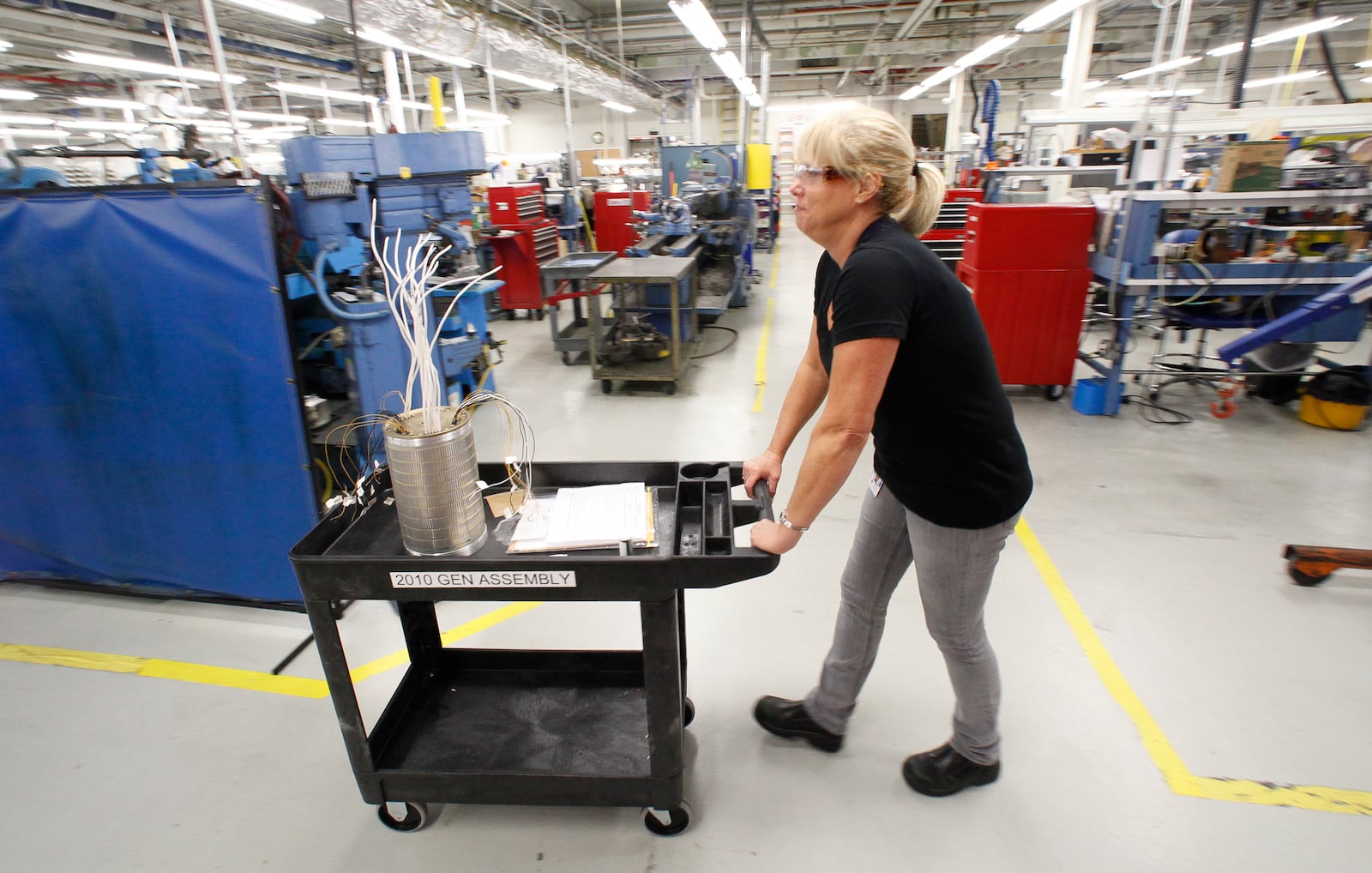 Angie Howell, a prodcut development lab assembler at GE Aviation in Vandalia, moves a compont used for electric generation aboard an F-18 Super Hornet. STAFF PHOTO BY CHRIS STEWART