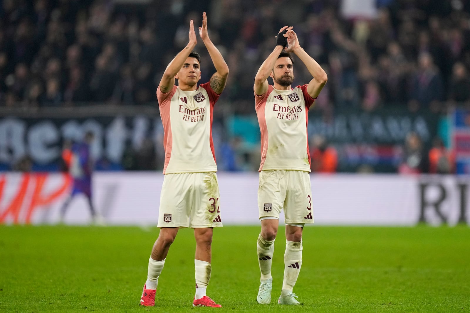 Lyon's Thiago Almada and Nicolas Tagliafico applaud fans at the end of the Europa League round of 16, first leg soccer match between FCSB and Lyon at the National Arena stadium, Thursday, March 6, 2025. (AP Photo/Andreea Alexandru)