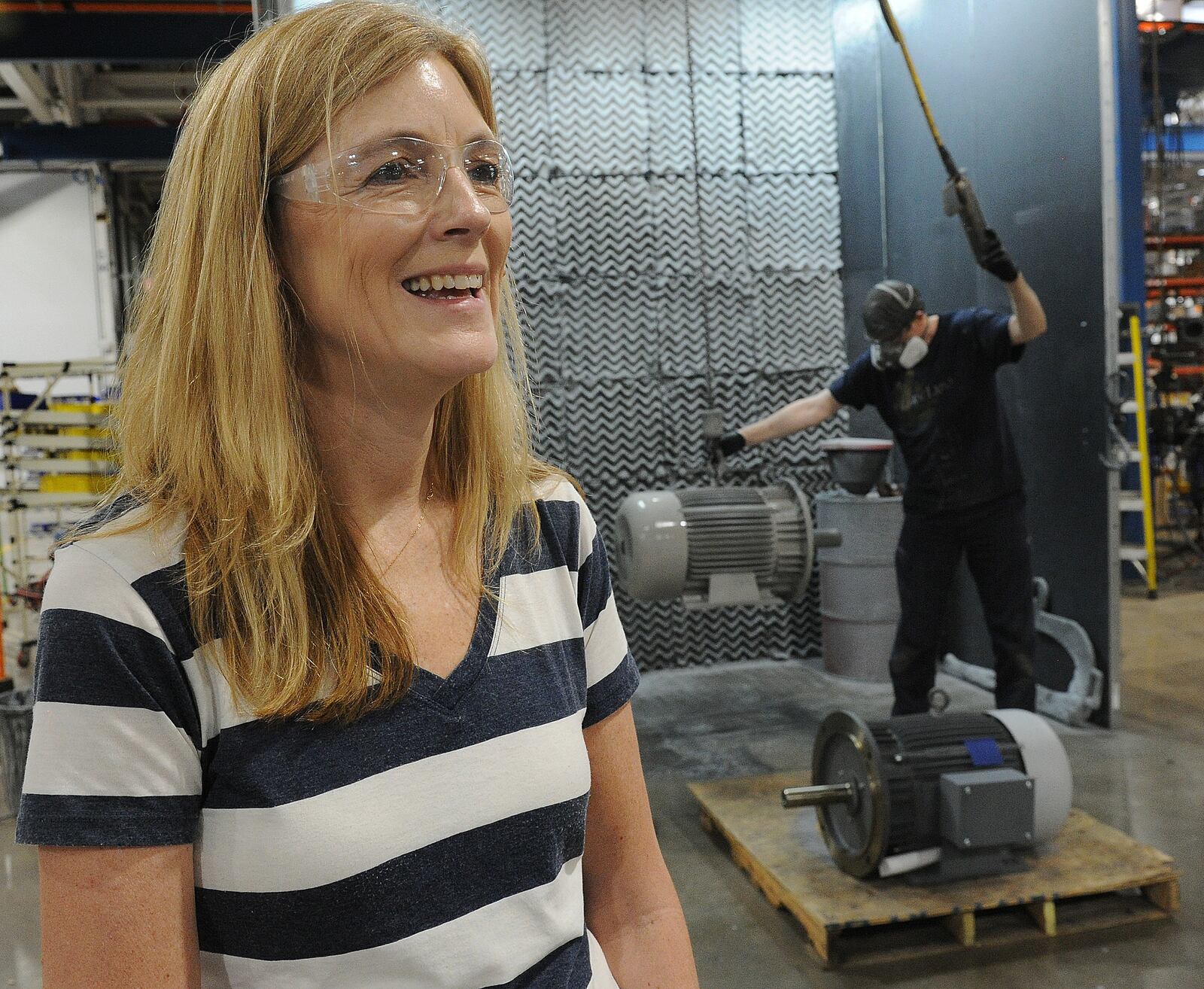 Christy Fox, the chief executive officer at Dayton-Phoenix, stands in front of the last machine installed at the plant on Kuntz Road in Old North Dayton. Fox said they decided to rebuild the plant after it was hit by a tornado three years ago. MARSHALL GORBY\STAFF