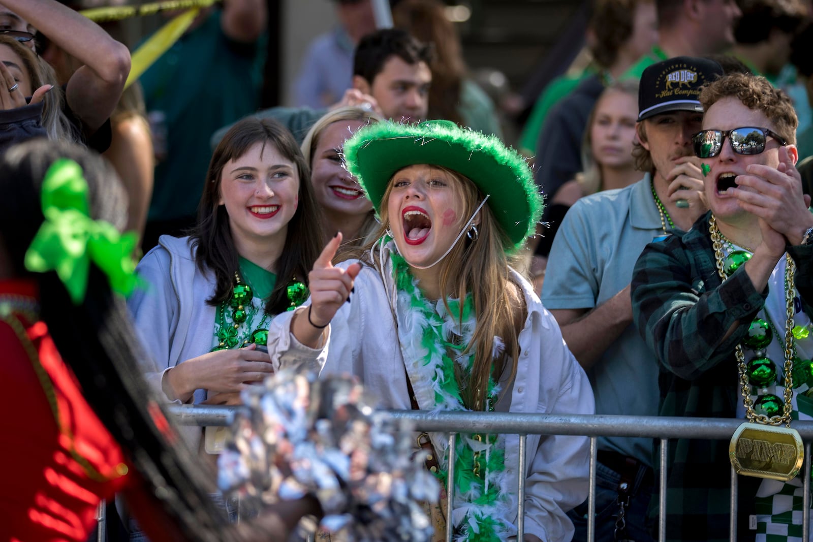 A group of local residents shout at group of cheerleaders during the St. Patrick's Day parade, Monday, March 17, 2025, in Savannah, Ga. (AP Photo/Stephen B. Morton)