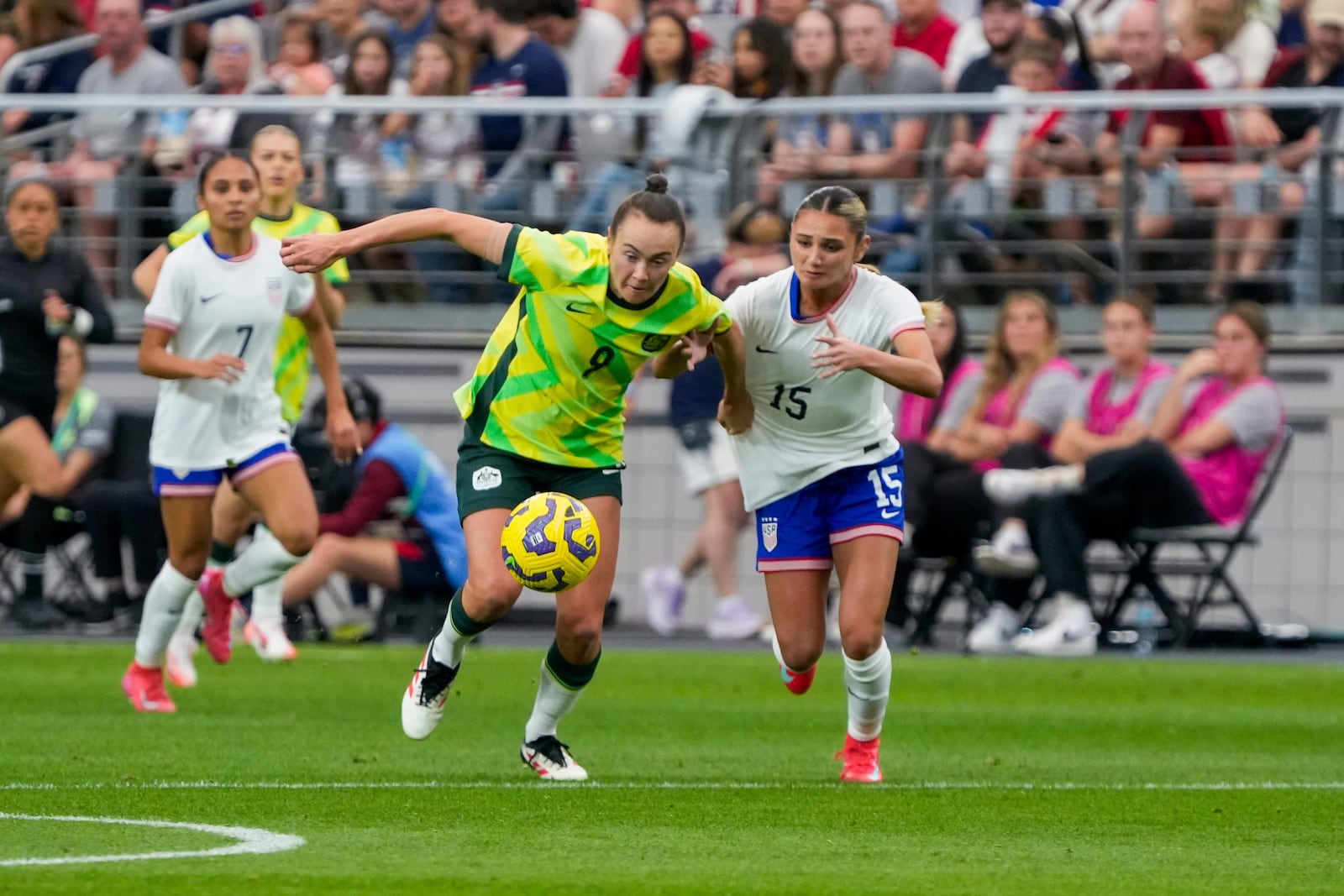 Australia forward Caitlin Foord (9) and United States defender Gisele Thompson (15) battle for the ball during the first half of a group stage match in the SheBelieves Cup women's soccer tournament, Sunday, Feb. 23, 2025, in Glendale, Ariz. (AP Photo/Samantha Chow)