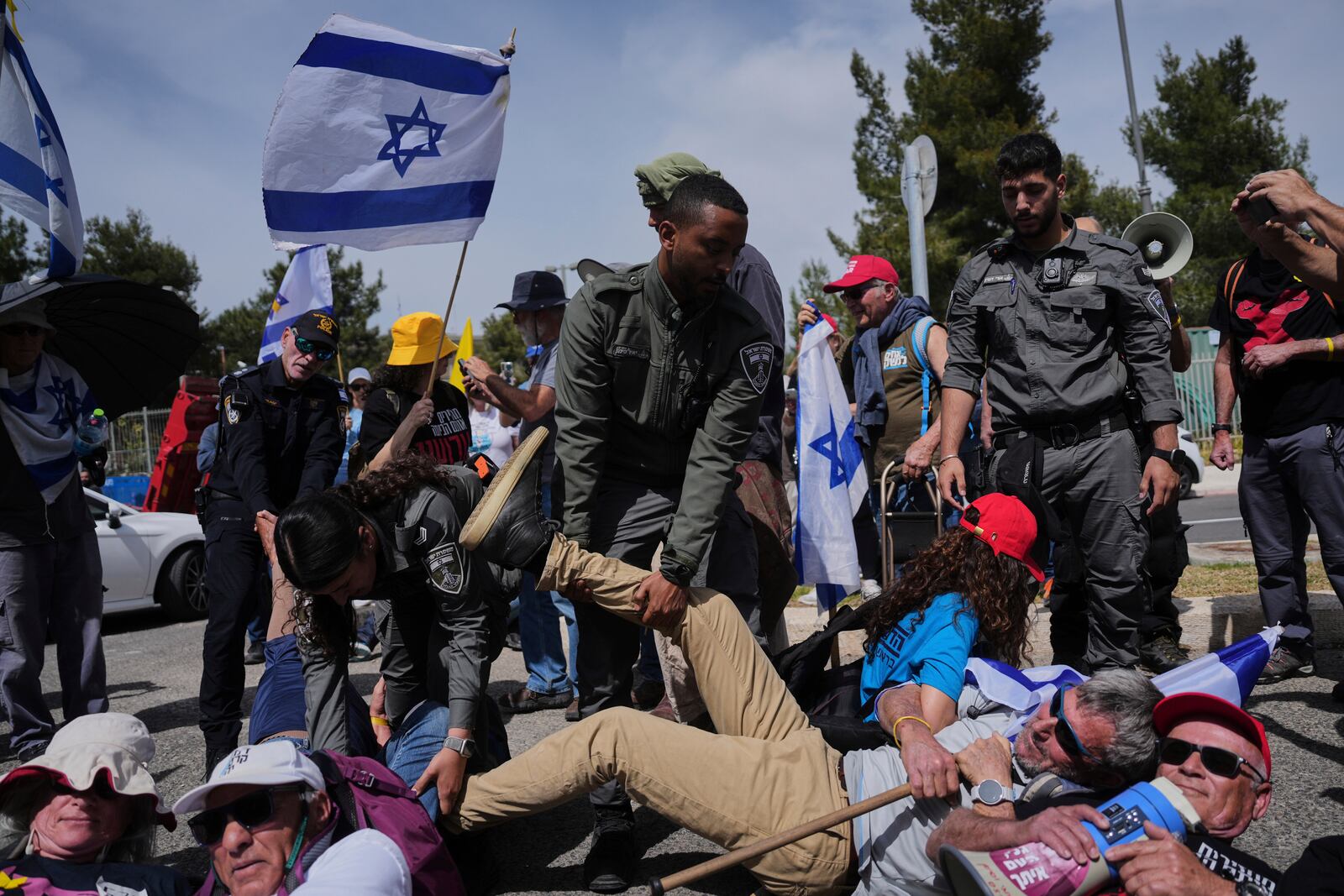 Israeli police officers disperse demonstrators as they block a road leading to the Israeli parliament during an anti-government protest ahead of a key vote on the state budget in Jerusalem, Tuesday, March 25, 2025. (AP Photo/Ohad Zwigenberg)