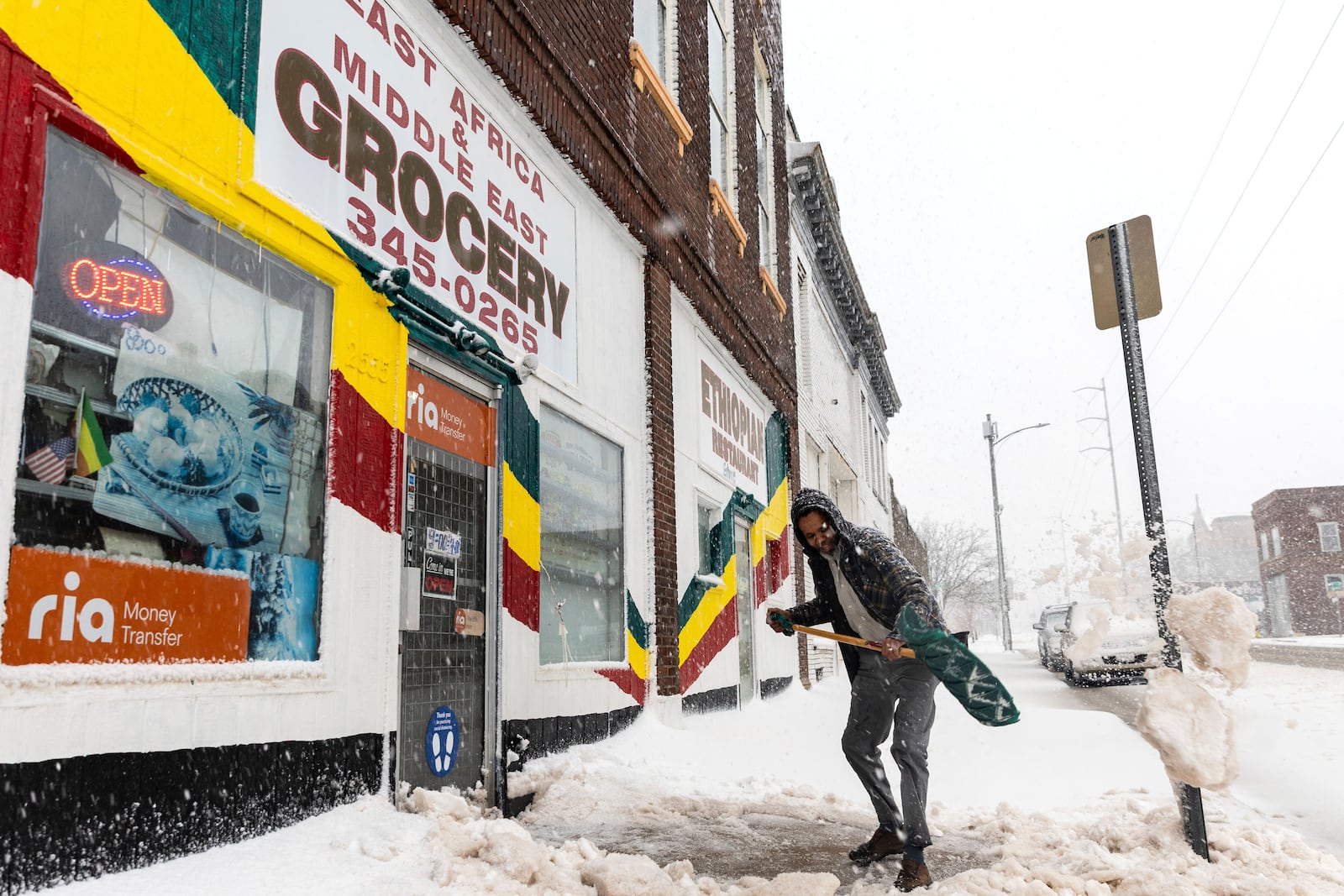 Ahmed Mohammed shovels in front of a grocery store during a blizzard in Omaha, Neb., on Wednesday, March 19, 2025. (Chris Machian/Omaha World-Herald via AP)