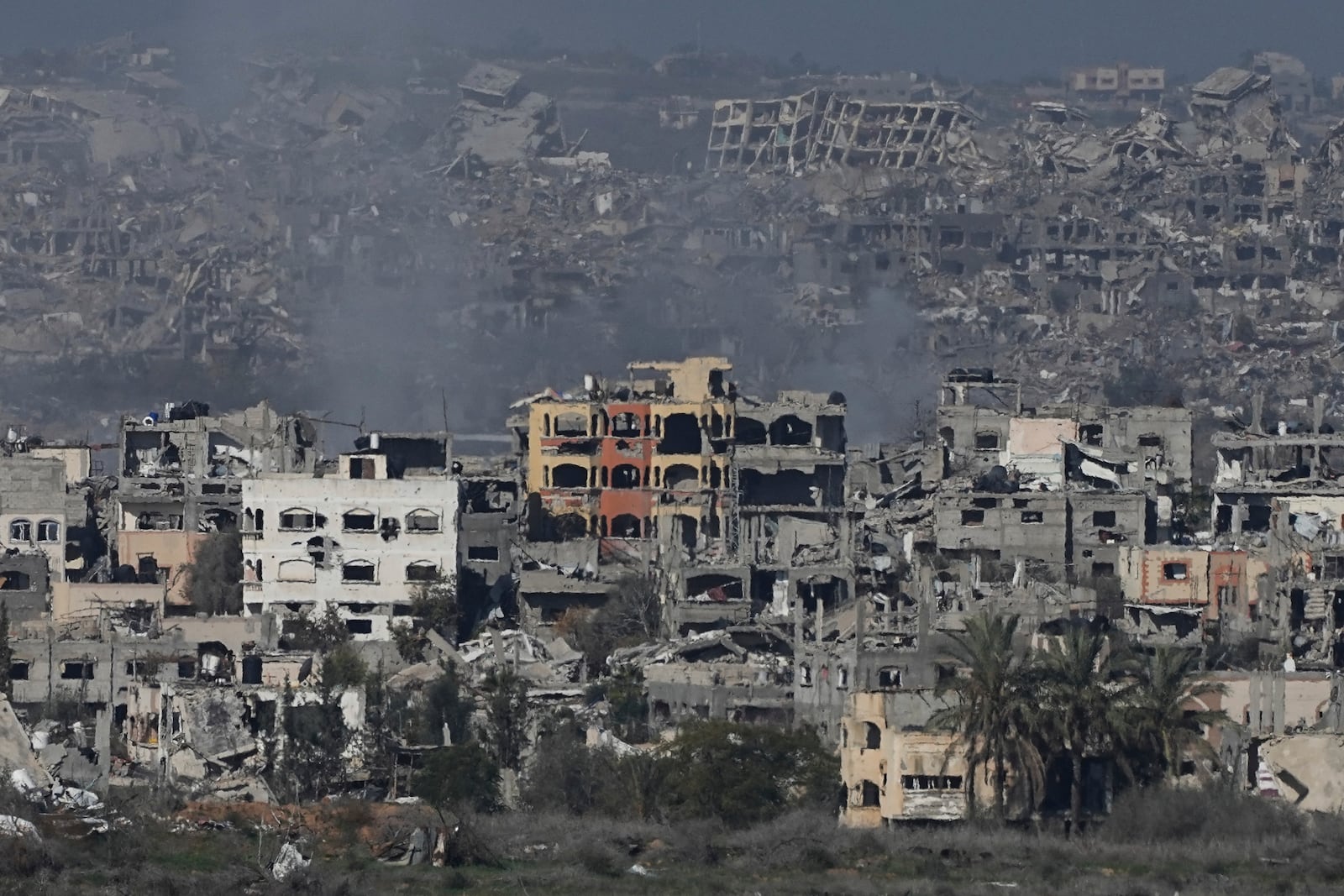 Destroyed buildings by Israeli bombardments are seen inside the Gaza Strip from southern Israel, on Tuesday, Jan. 14, 2025. (AP Photo/Tsafrir Abayov)