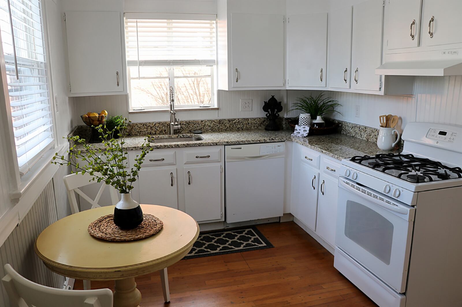 The kitchen features white cabinetry along two walls as well as a granite countertop. Ceramic-tile accents the wall space between the hanging cabinets and countertops. The floor plan allows for easy preparation space with a window above the sink. CONTRIBUTED PHOTO BY KATHY TYLER