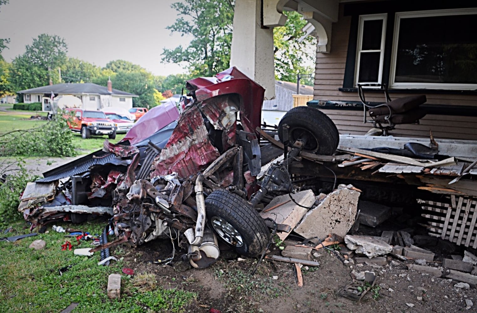 Tanker truck strikes pole, porch, other cars