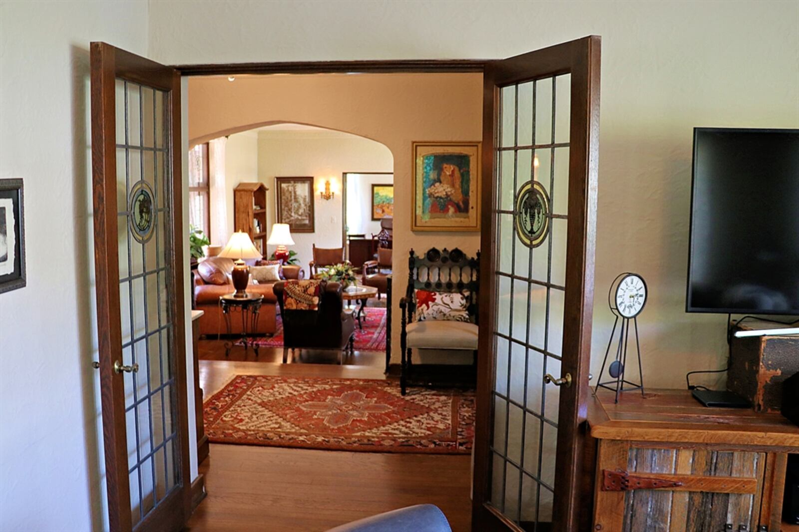 French doors open off the living room to a study that has a parquet floor. 