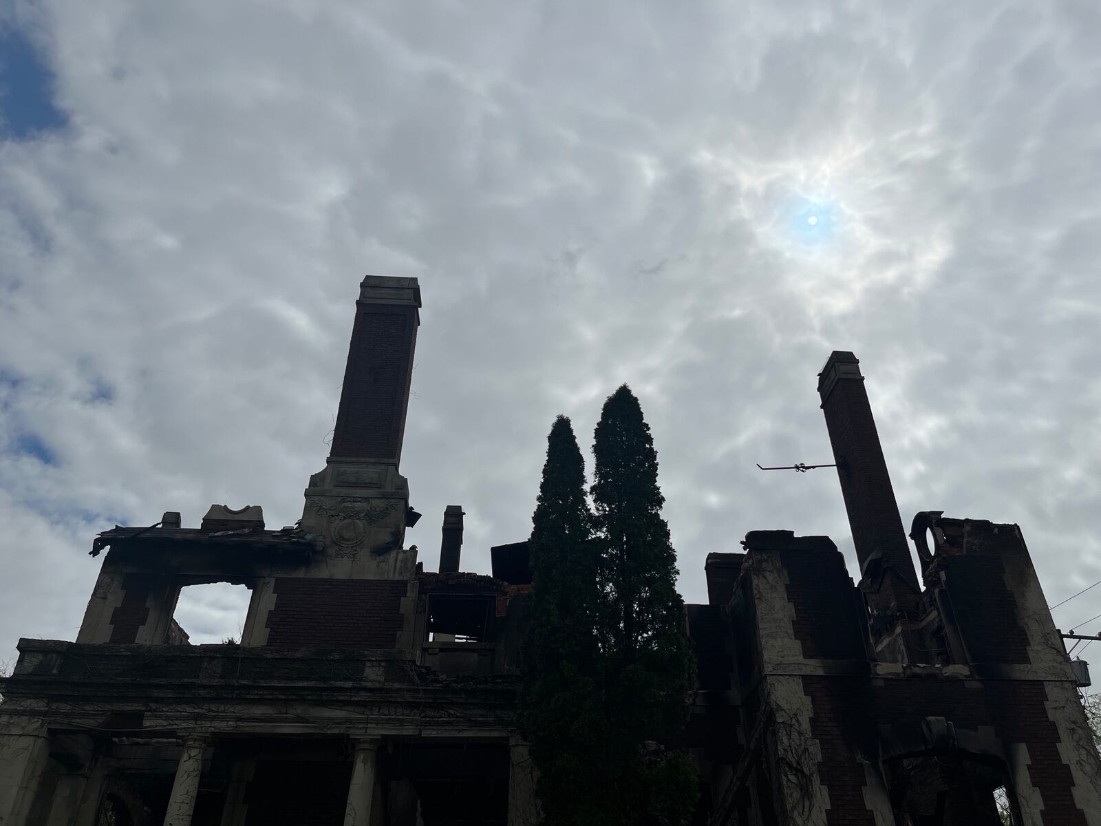 The sun barely peeks through on Sunday, April 23, 2023, overlooking the Traxler Mansion at the corner of Broadway and Yale in West Dayton, which was badly damaged by fire. JEREMY P. KELLEY / STAFF