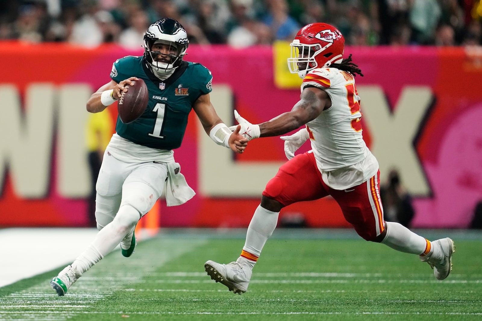 Philadelphia Eagles quarterback Jalen Hurts (1) eludes the reach of Kansas City Chiefs defensive end Mike Danna during the second half of the NFL Super Bowl 59 football game, Sunday, Feb. 9, 2025, in New Orleans. (AP Photo/Ashley Landis)