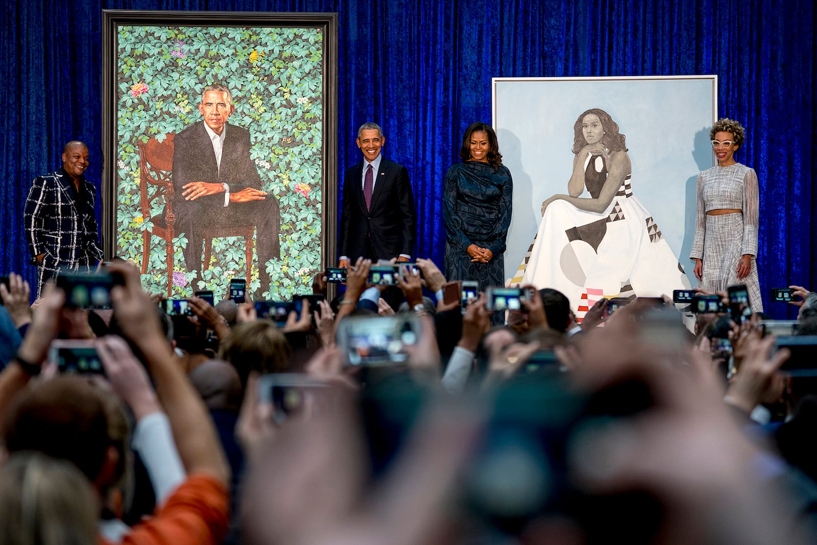 From left, artist Kehinde Wiley, who painted former President Barack Obama's portrait, former President Barack Obama, former first lady Michelle Obama, and artist Amy Sherald, who painted Michelle Obama's portrait, stand on stage together during an unveiling ceremony at the Smithsonian's National Portrait Gallery, Monday, Feb. 12, 2018, in Washington. (AP Photo/Andrew Harnik)