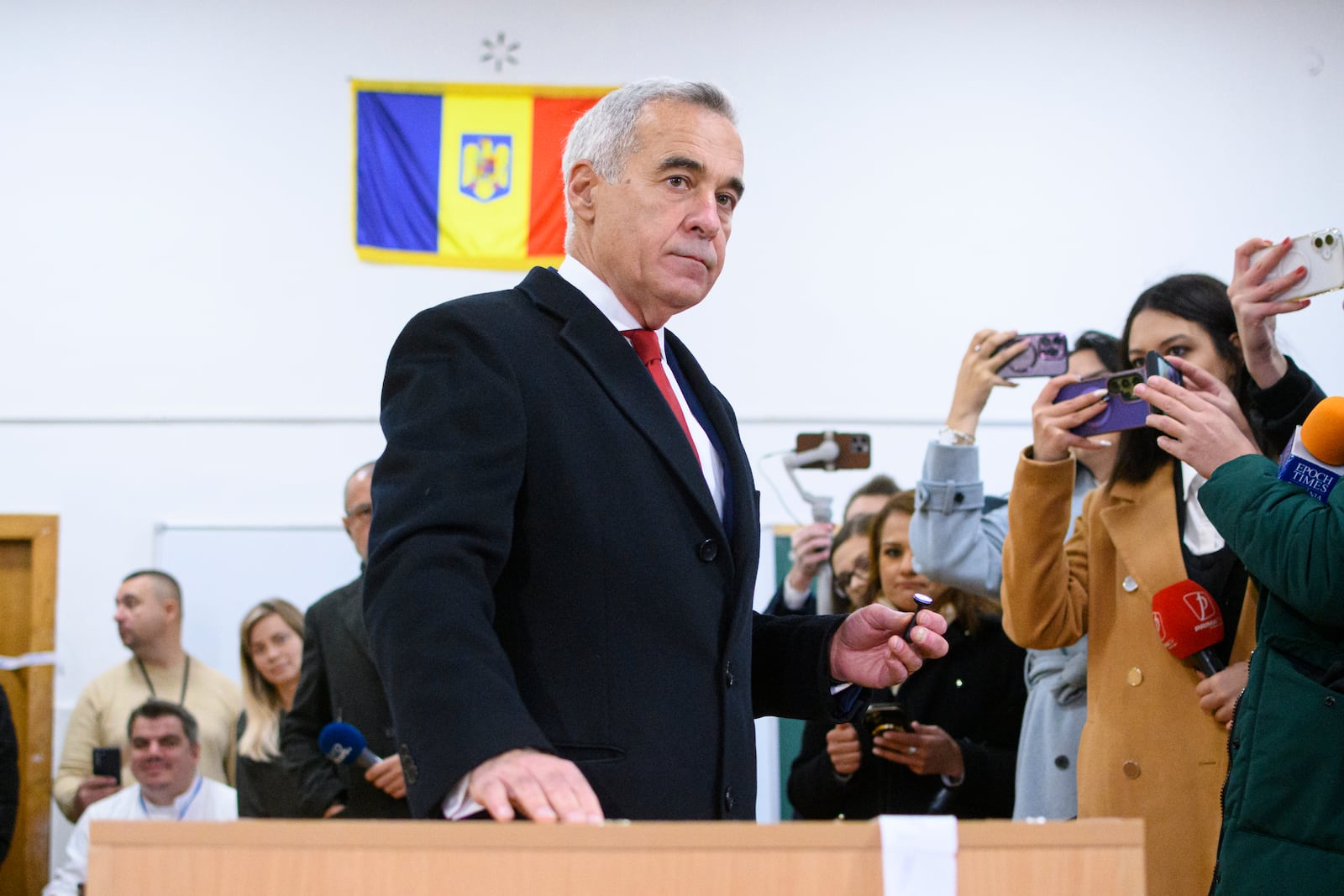 Calin Georgescu, an independent candidate for president who came first after the first round of presidential elections, casts his vote in the country's parliamentary elections, in Mogosoaia, Romania, Sunday, Dec. 1, 2024. (AP Photo/Alexandru Dobre)