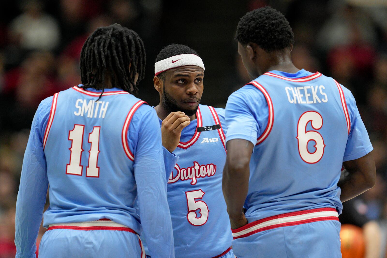 Dayton's Posh Alexander (5) speaks with teammates Enoch Cheeks (6) and Malachi Smith (11) during the first half of an NCAA college basketball game against Cincinnati, Friday, Dec. 20, 2024, in Cincinnati. (AP Photo/Jeff Dean)