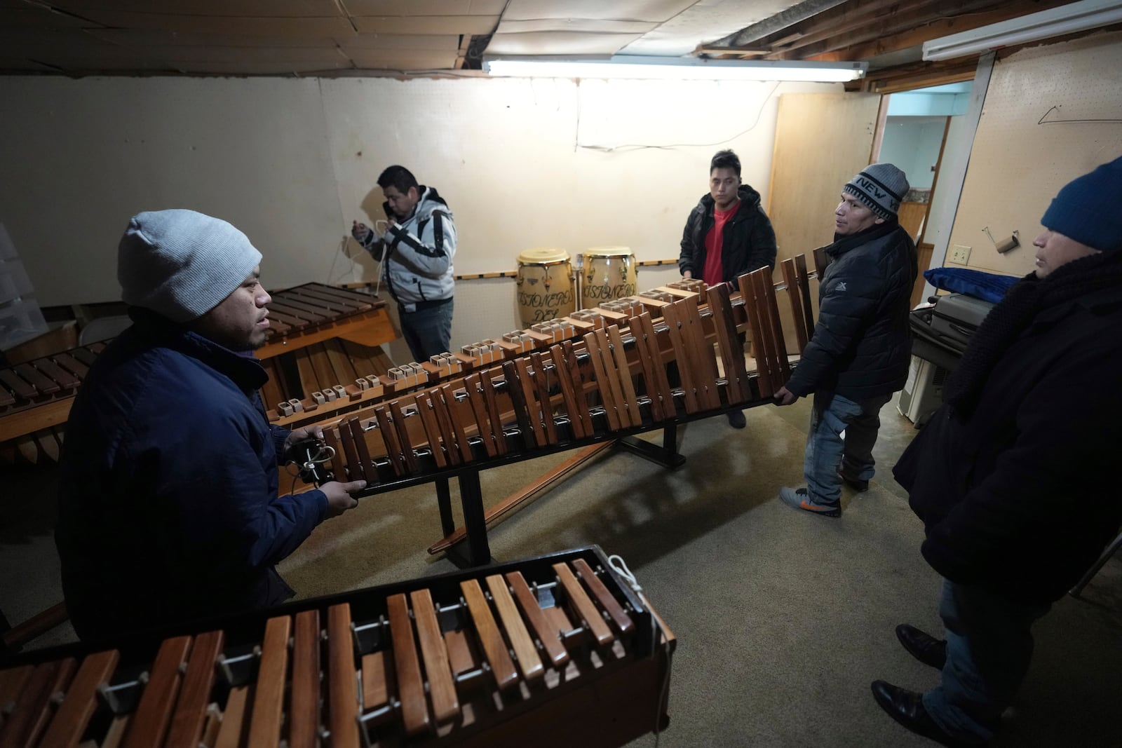 Benigno Miranda, right, carries a marimba to take to Saint Mary's Catholic Church, where his group is organizing a celebration for the feast day of Guatemala's Black Christ of Esquipulas in Worthington, Minnesota, Saturday, Jan. 11, 2025. (AP Photo/Abbie Parr)