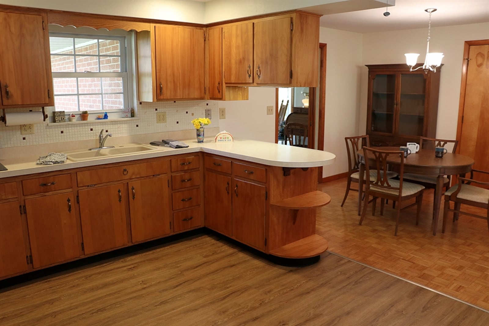 A peninsula counter with a curved top divides the kitchen from the dining room. The curved, extended counter allows for a couple of bar seats.