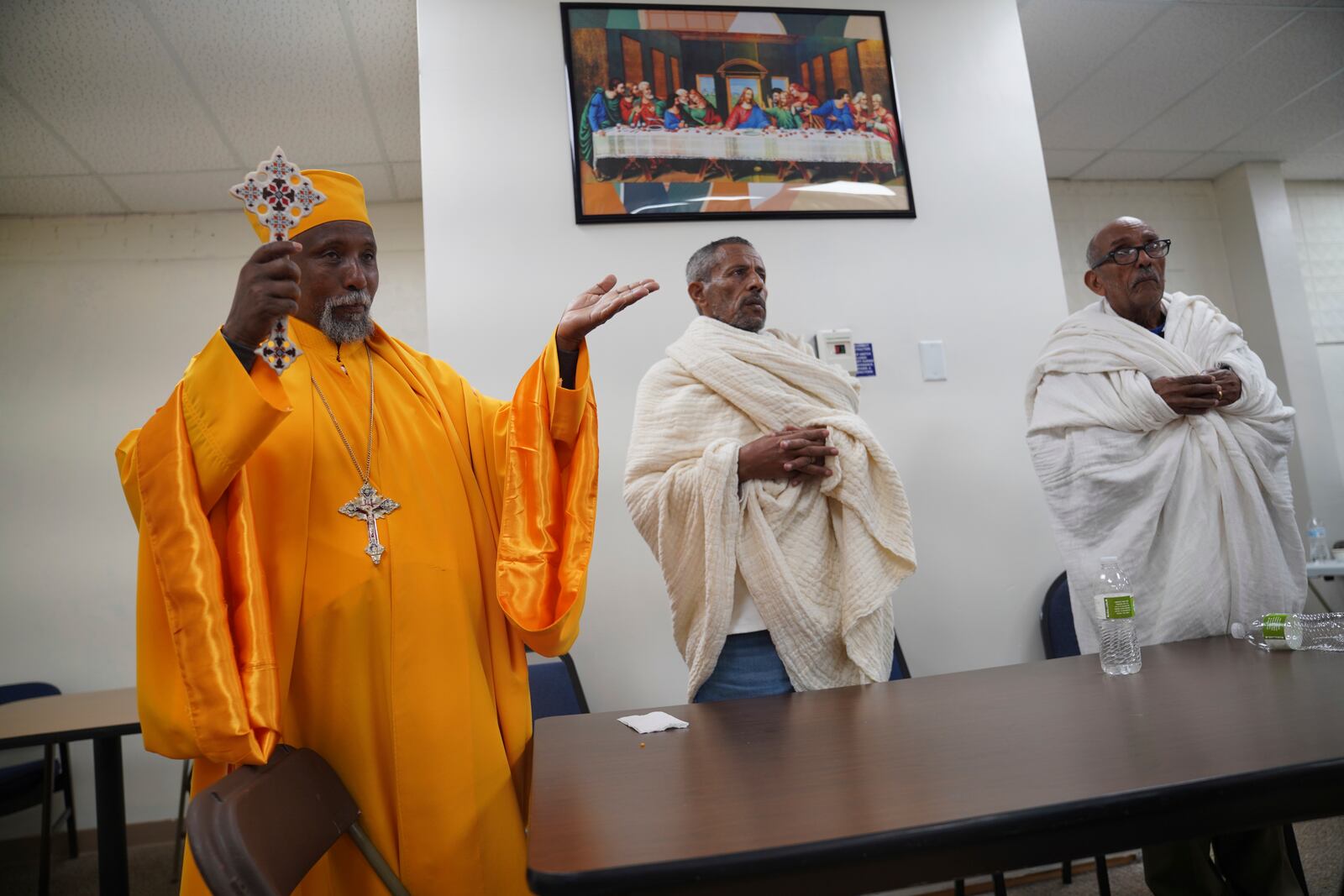 A priest, left, leads prayers at the Ethiopian Orthodox Tewahedo Church after a post-liturgy lunch on Sunday, Oct. 20, 2024, in Worthington, Minn. (AP Photo/Jessie Wardarski)