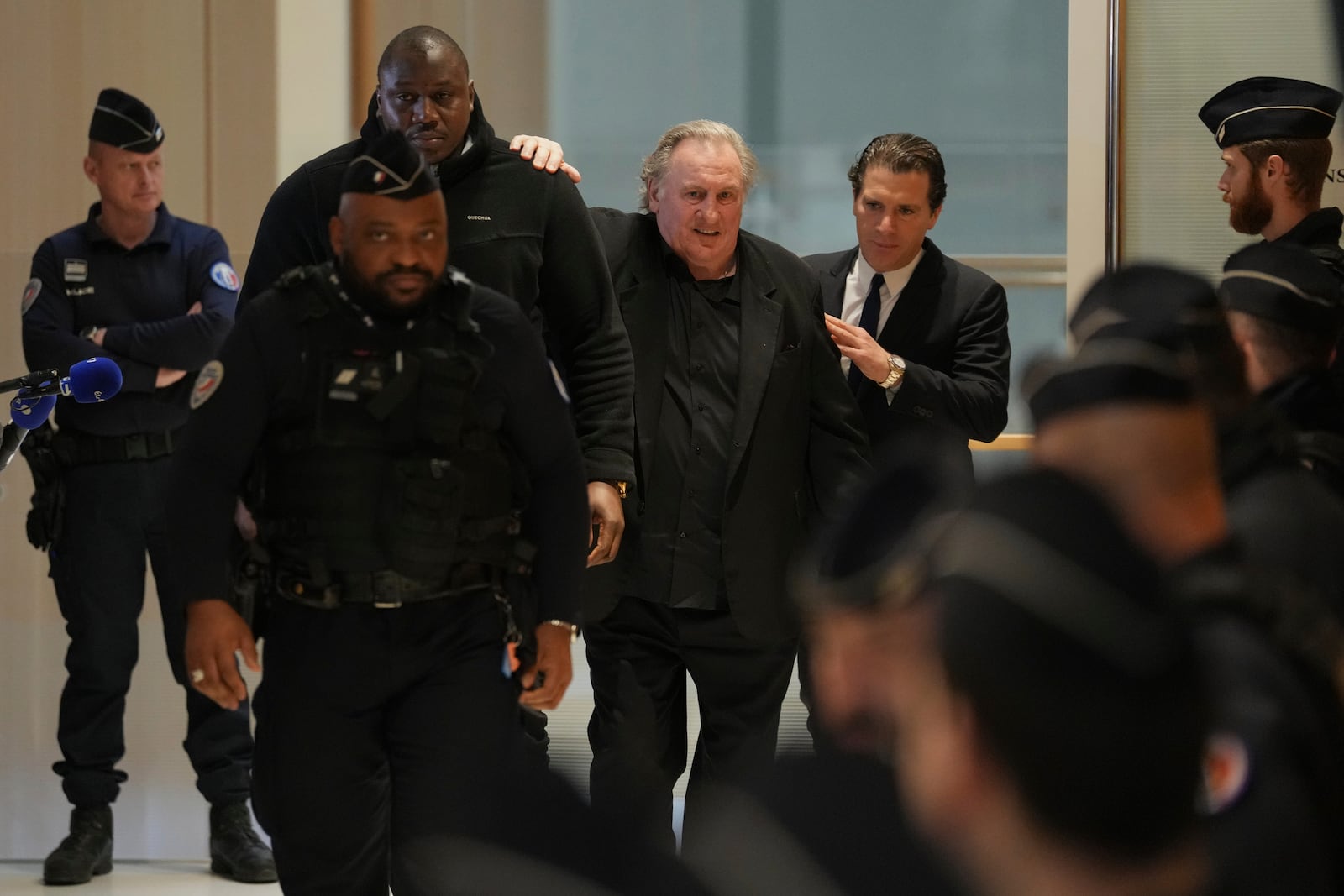 Actor Gerard Depardieu, center, leaves with his lawyer Jeremie Assous, right, to the courtroom for a break during his trial for the alleged sexual assaults of two women on a film set in 2021, Tuesday, March 25, 2025 in Paris. (AP Photo/Aurelien Morissard)