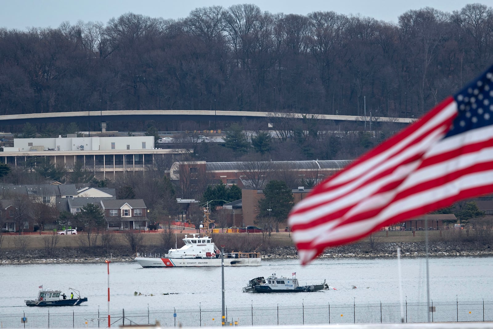 Police and coast guard boats are seen around a wreckage site in the Potomac River from Ronald Reagan Washington National Airport, Thursday, Jan. 30, 2025, in Arlington, Va. (AP Photo/Jose Luis Magana)