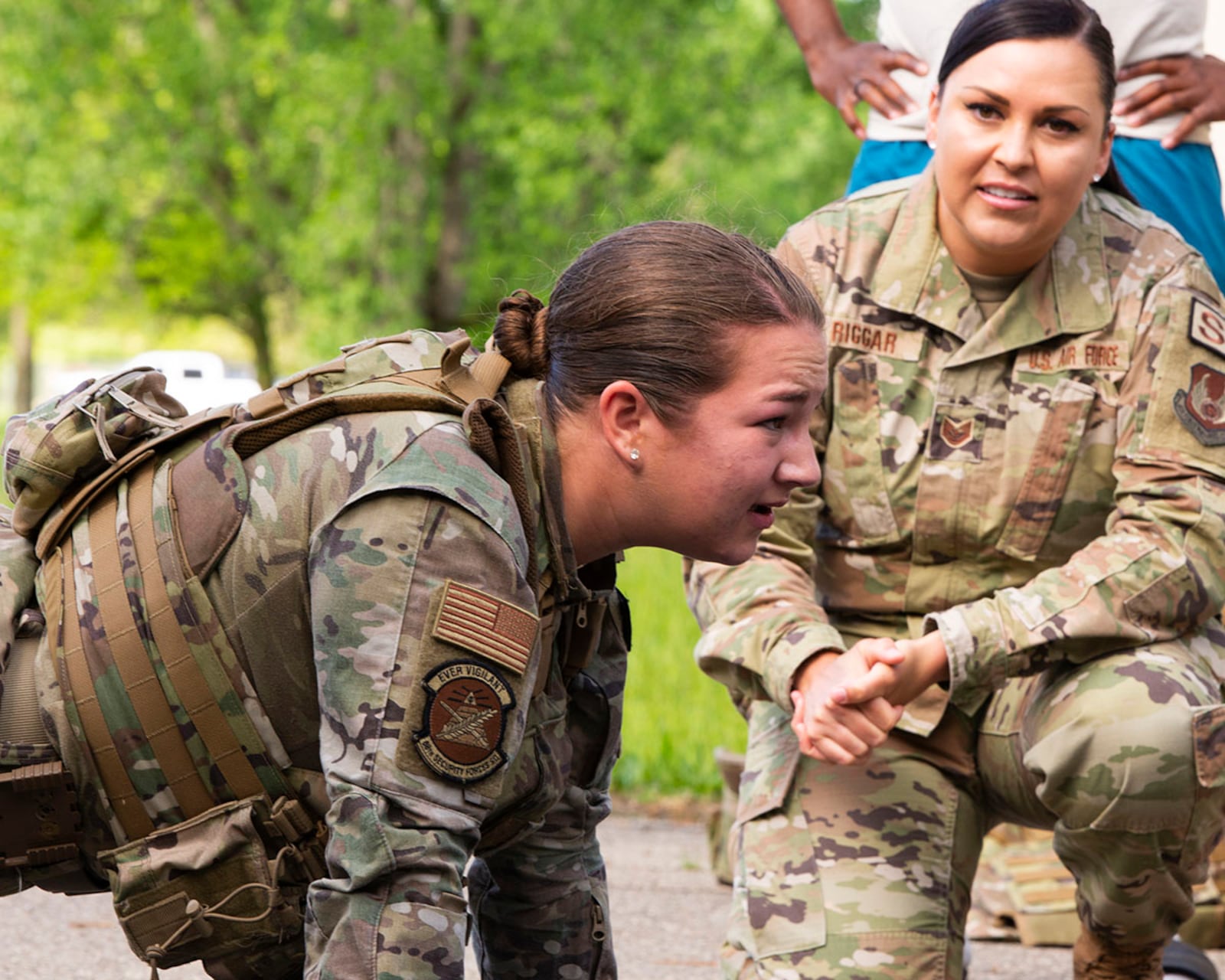 Airman 1st Class Hannah Browning tests her physical endurance in the pushup competition May 16 while Tech. Sgt. Olivia Riggar gives encouragement during the Defenders Challenge, part of National Police Week at Wright-Patterson Air Force Base. U.S. AIR FORCE PHOTO/JAIMA FOGG