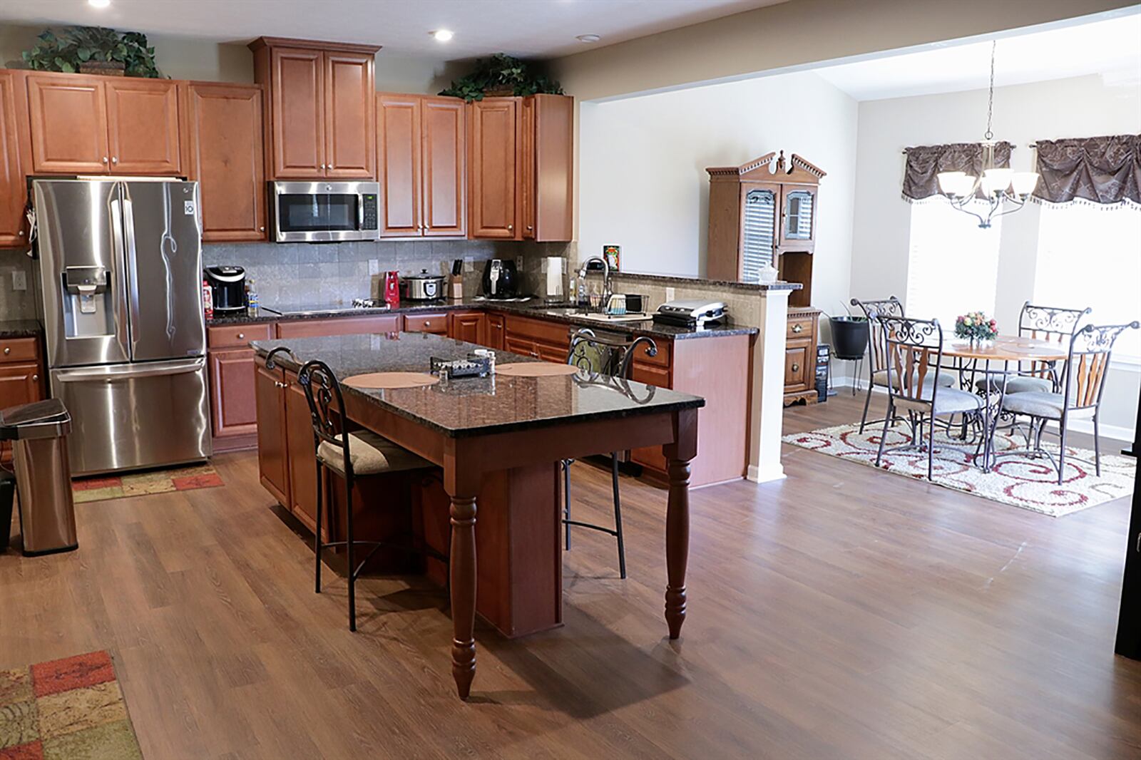 Light cherry cabinetry fills two walls of the kitchen and has complementing granite countertops. Stainless-steel appliances include double wall ovens, a microwave, a glass cooktop, a dishwasher and a refrigerator. Stone tiles accent the walls space. CONTRIBUTED PHOTO BY KATHY TYLER