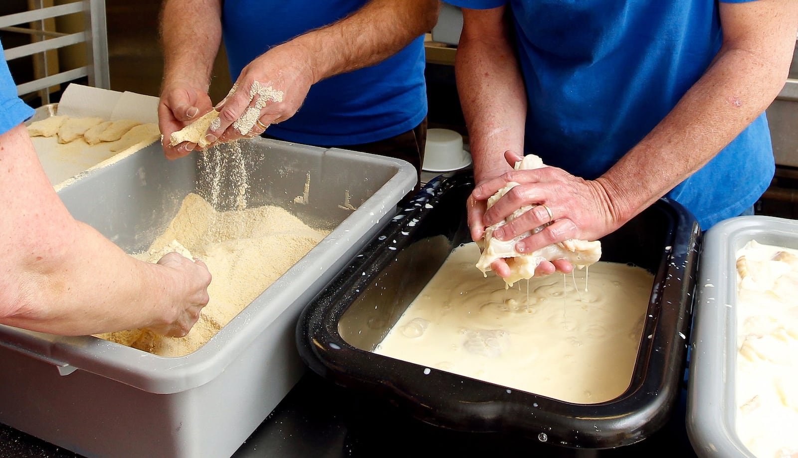 The Hecht family and friends batter Icelandic Cod fillets to be fried at Friday night’s fish fry at Fenwick High School last March in Middletown. The Hecht family has been throwing fish fry events for more than 50 years. NICK DAGGY / STAFF