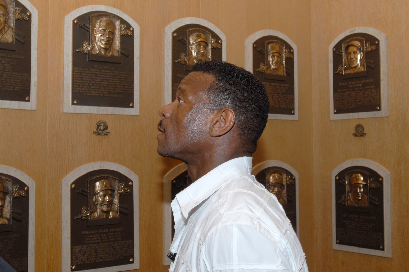 FILE - Class of 2009 Baseball Hall of Fame inductee Rickey Henderson views plaques on a tour of the National Baseball Hall of Fame and Museum in Cooperstown, N.Y., May 8, 2009. (AP Photo/Tim Roske, File)