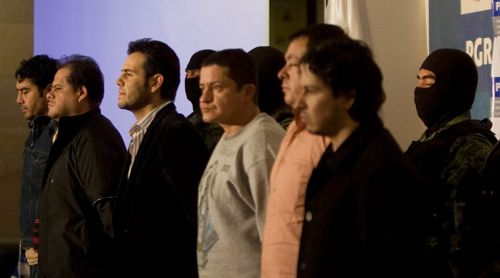 FILE - Military officers guard alleged drug trafficker Vicente Zambada, third left front, and five unidentified men who were presented to the press as Zambada's alleged bodyguards in Mexico City, March 19, 2009. Vicente Zambada is the son of Mexican drug lord Ismael Zambada, head of the Sinaloa cartel. (AP Photo/Eduardo Verdugo, File)