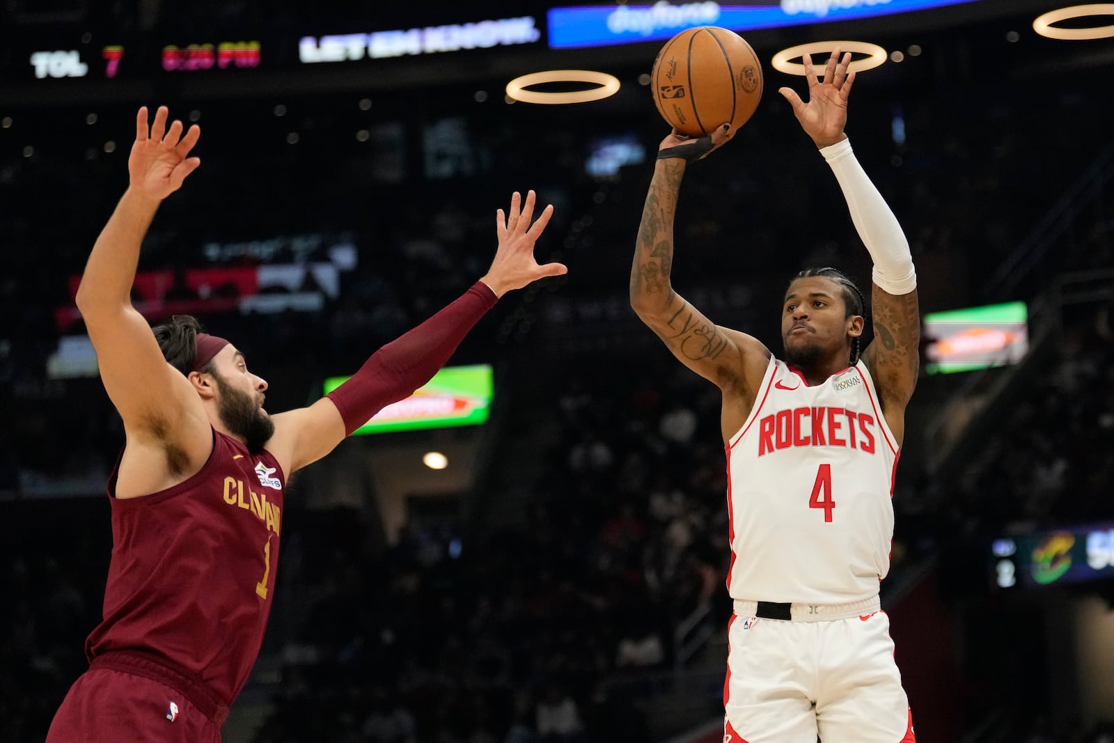 Houston Rockets guard Jalen Green (4) shoots over Cleveland Cavaliers guard Max Strus, left, in the first half of an NBA basketball game, Saturday, Jan. 25, 2025, in Cleveland. (AP Photo/Sue Ogrocki)