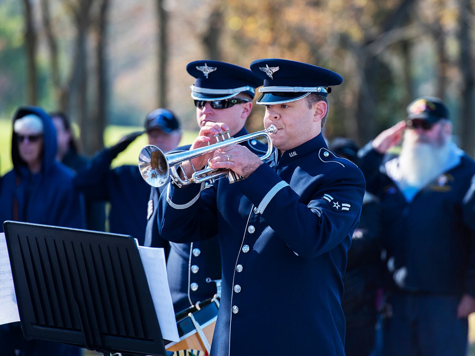 Airman 1st Class James Nufer, Air Force Band of Flight, plays taps Nov. 6 as veterans in the audience salute during the dedication and ribbon cutting for the new Veterans Memorial Park at Thomas A. Cloud Park in Huber Heights. U.S. AIR FORCE PHOTO/R.J. ORIEZ