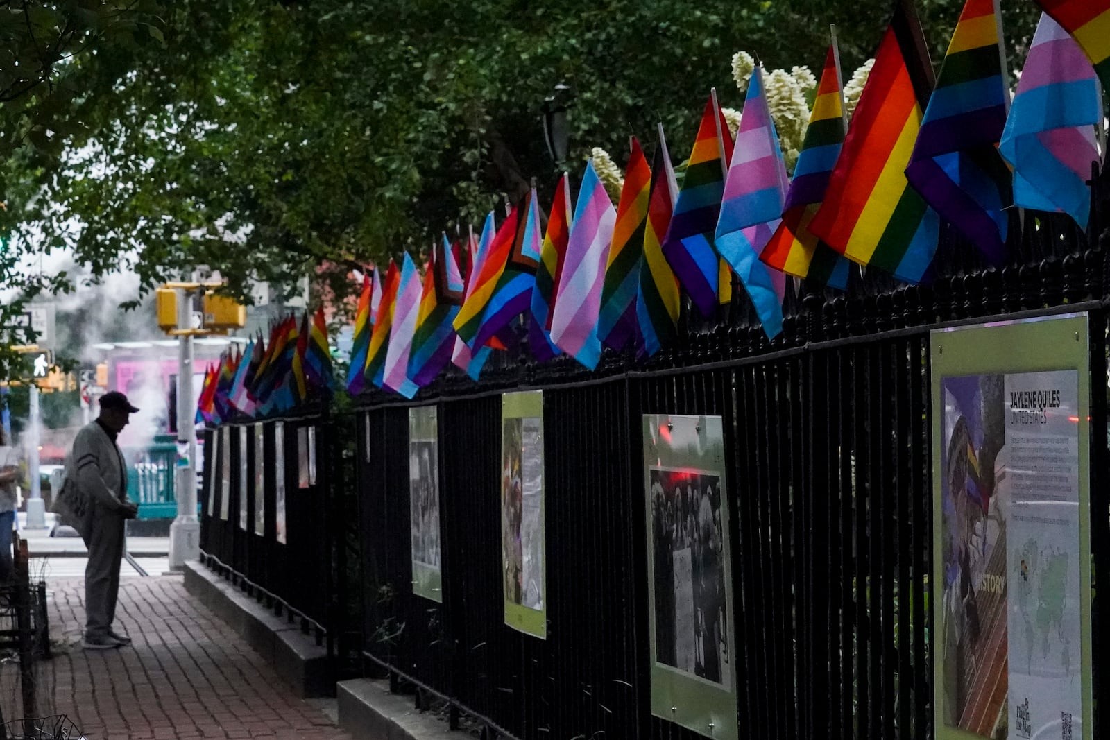 FILE - A visitor views a historical exhibit of the Gay rights movement, displayed on fencing dressed with flags affirming LGBTQ identity at the Stonewall National Monument, Wednesday, June 22, 2022, in New York. (AP Photo/Bebeto Matthews, File)