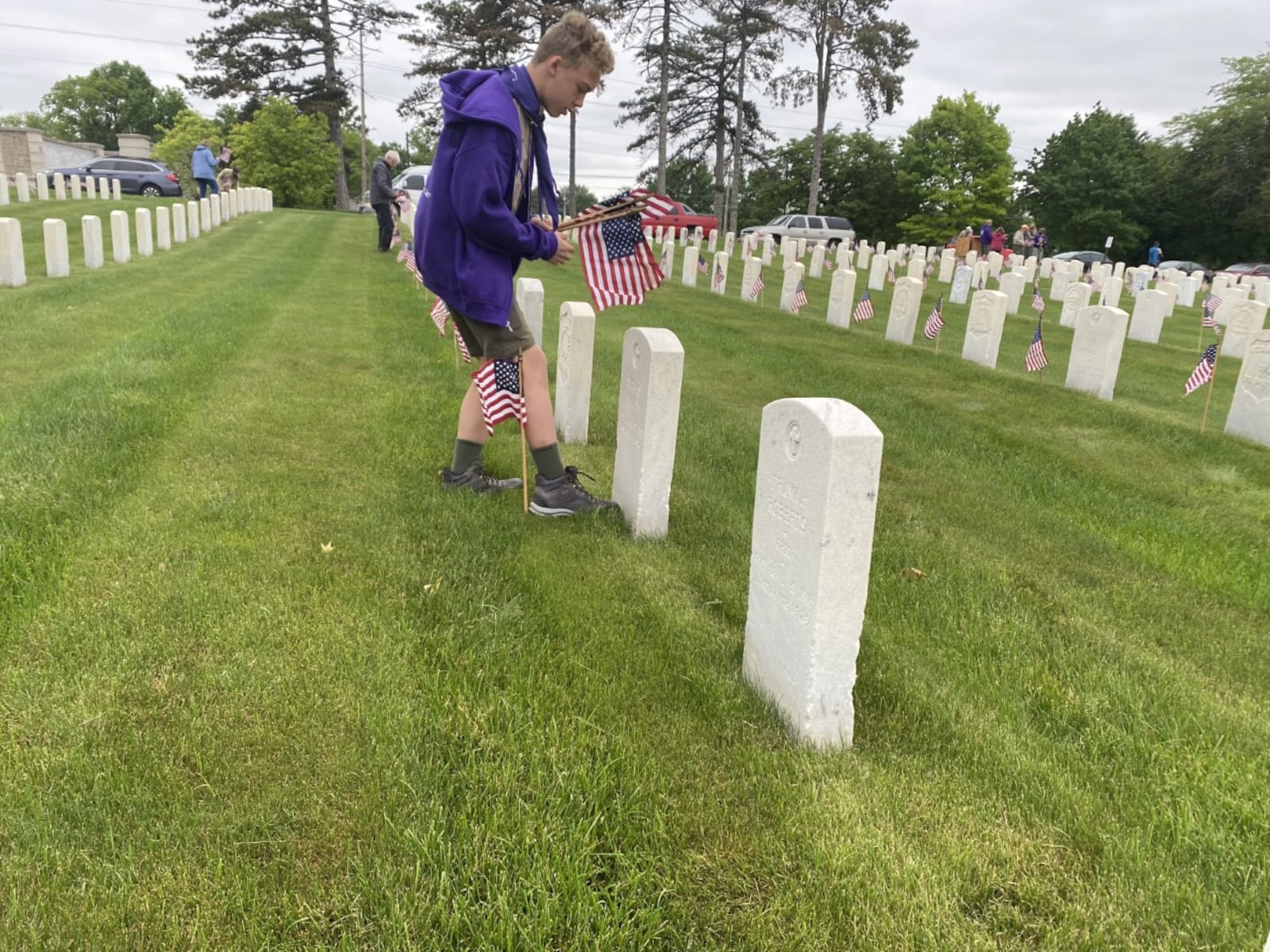 Will Deel, 12, of Troop 236 in Kettering, places flags on veteran's graves at the Dayton National Cemetery on Saturday, May 29. Eileen McClory / Staff