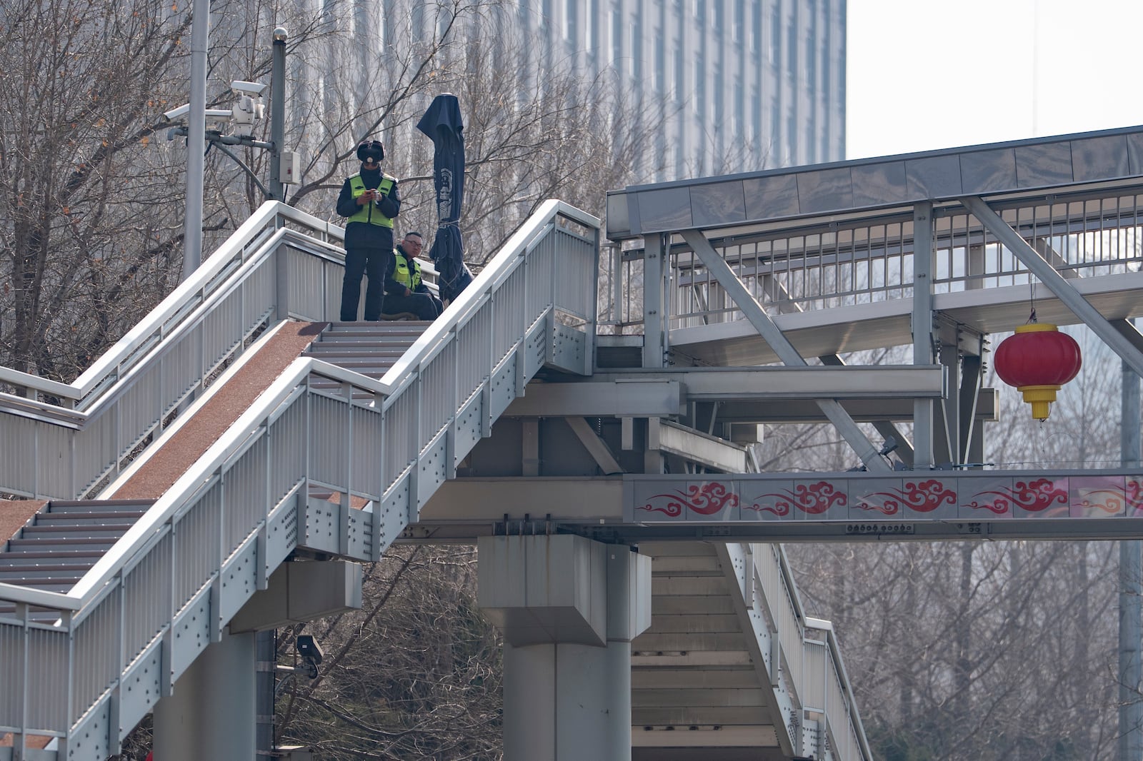 Chinese security personnel monitor an overhead bridge ahead of the National People's Congress in Beijing, on Feb. 28, 2025. (AP Photo/Ng Han Guan)