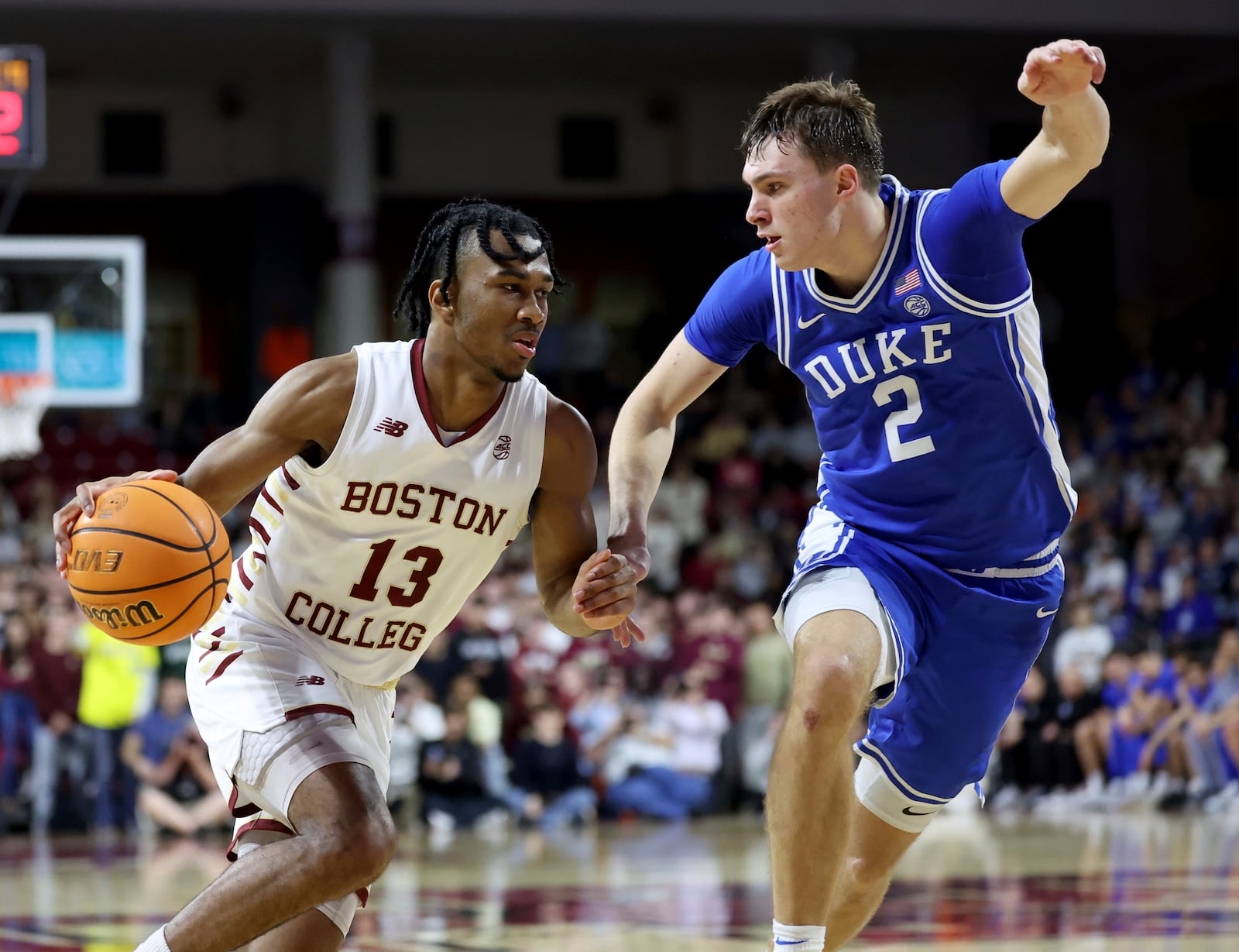 Boston College guard Donald Hand Jr. (13) dribbles around Duke guard Cooper Flagg (2) during the second half of an NCAA college basketball game Saturday, Jan. 18, 2025, in Boston. (AP Photo/Mark Stockwell)