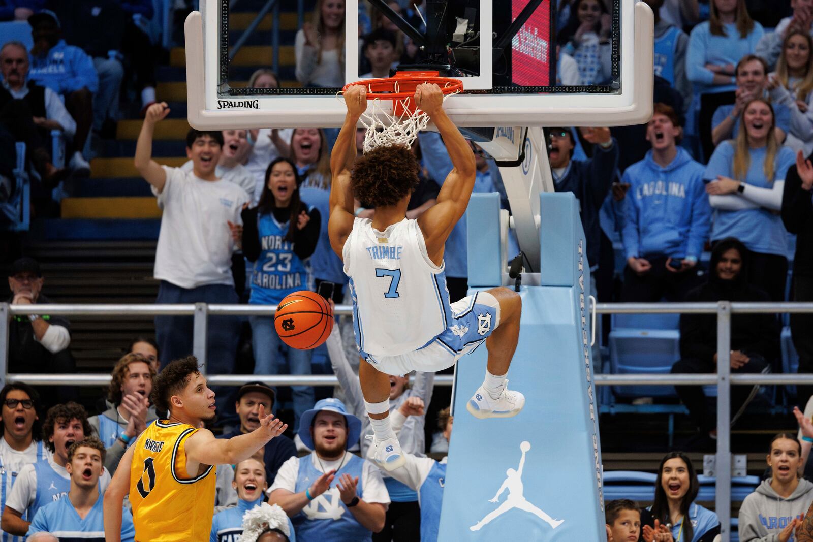 North Carolina's Seth Trimble (7) finishes a dunk over La Salle's Andrés Marrero (0) during the second half of an NCAA college basketball game in Chapel Hill, N.C., Saturday, Dec. 14, 2024. (AP Photo/Ben McKeown)