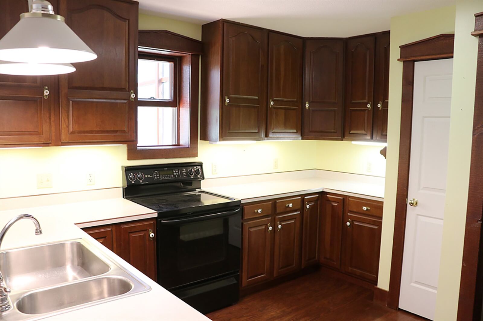 The kitchen is U-shaped in design with beveled countertops and walnut cabinetry. There is a double sink within the peninsula and a planning desk area, perfect for a coffee station. Appliances include a range, microwave on a shelf, dishwasher and refrigerator. CONTRIBUTED PHOTO BY KATHY TYLER