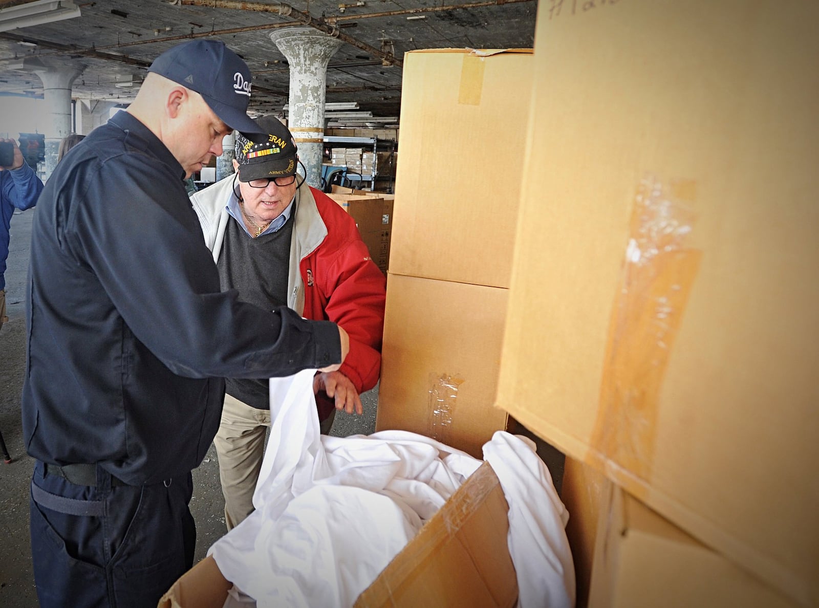 Sandy Mendelson, owner of Mendelsons, right, looks through boxes with Dayton firefighter Scott Jacobs at the giant warehouse Thursday. Mendelson donated several truck loads of items to the fire and police departments. MARSHALL GORBYSTAFF