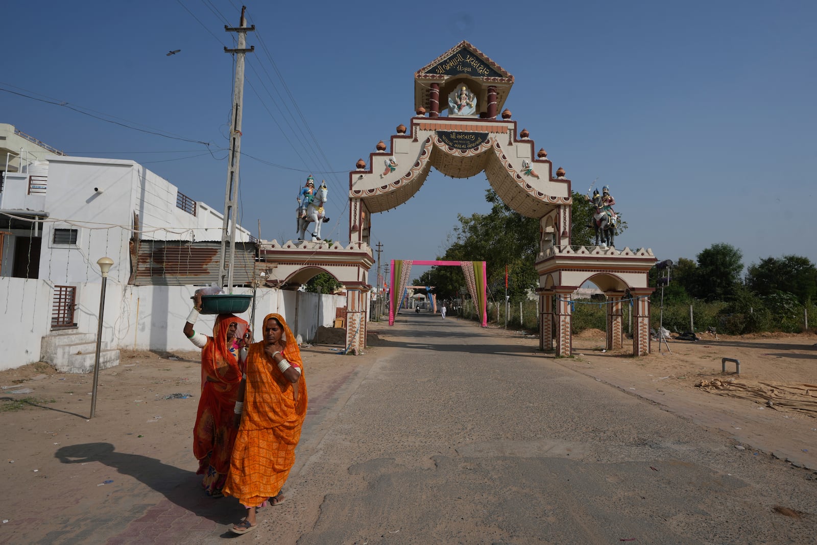 Women walks past an entrance gate of Dingucha village in Gandhinagar, India, Tuesday, Nov. 12, 2024. (AP Photo/Ajit Solanki)